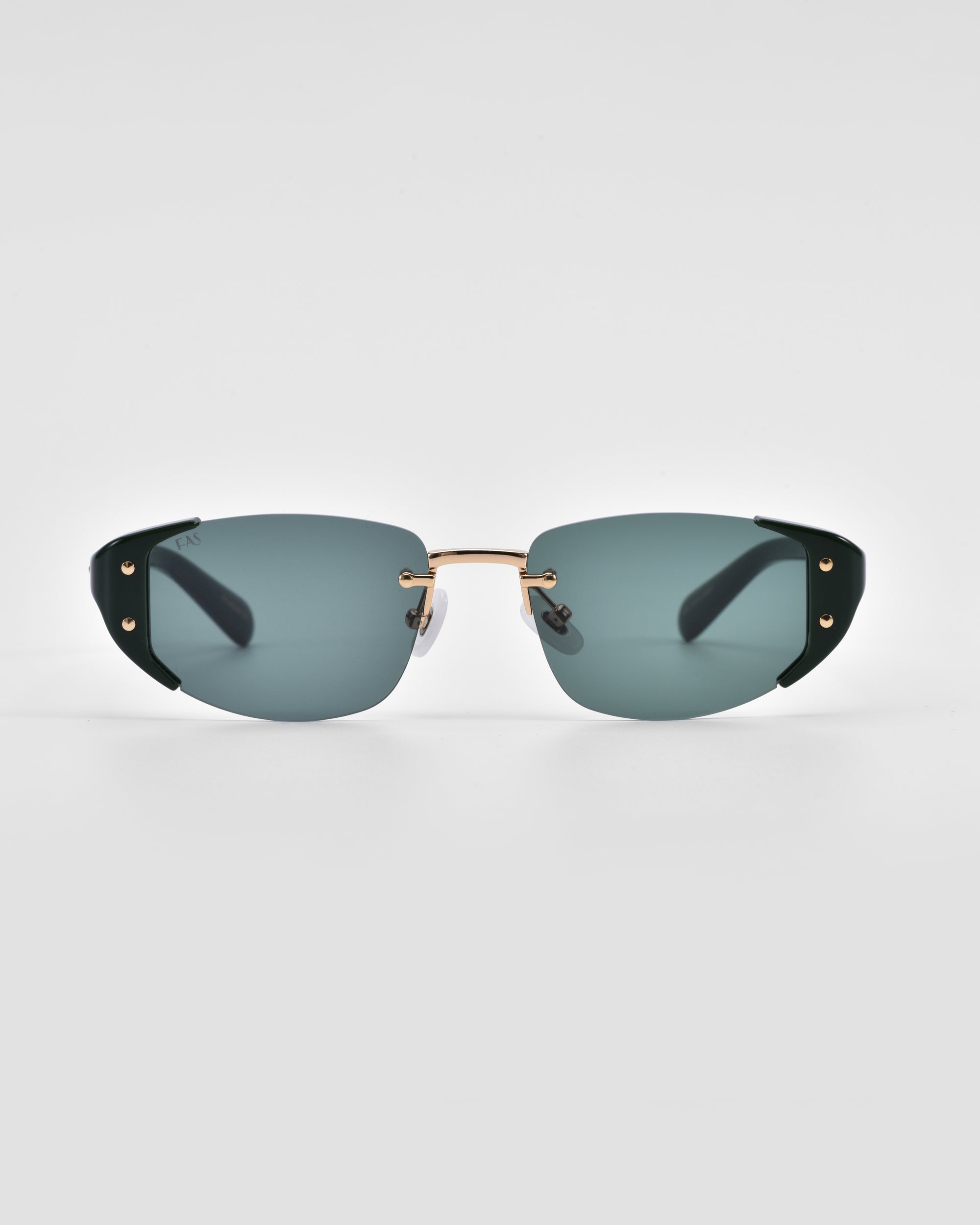 A pair of sleek, modern For Art's Sake® Harbour sunglasses with green-tinted lenses and a minimalistic design. The frames are thin and predominantly gold with black accents on the temples, complemented by jade-stone nose pads. The background is plain white, emphasizing the stylish eyewear.