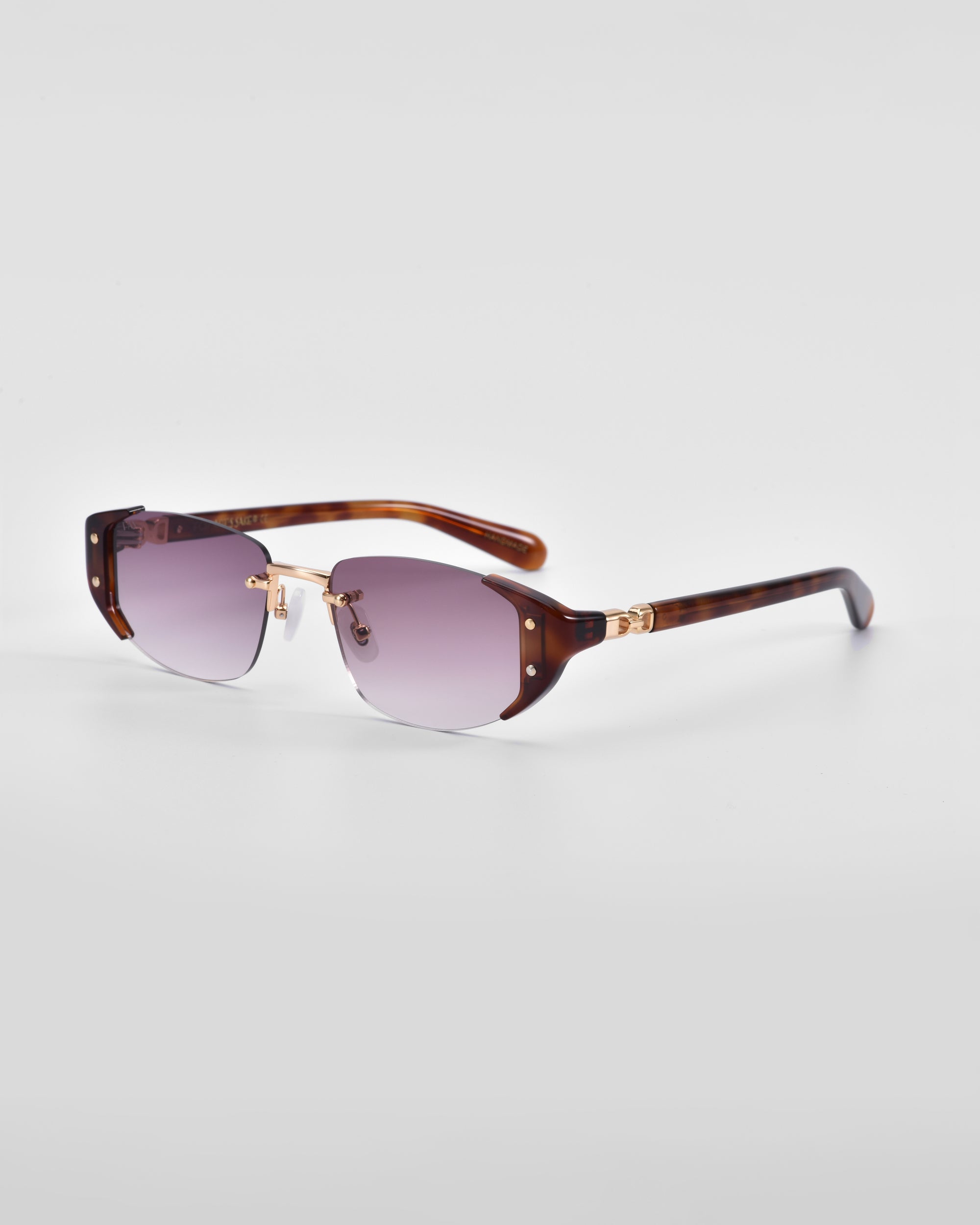 The For Art's Sake® Harbour sunglasses boast a retro-inspired design with gradient lenses shading from purple to clear. The tortoiseshell-patterned frames feature 18 karat gold plating accents, and the lenses are partially rimless with the top rim matching the tortoiseshell design. The look is both sleek and modern.