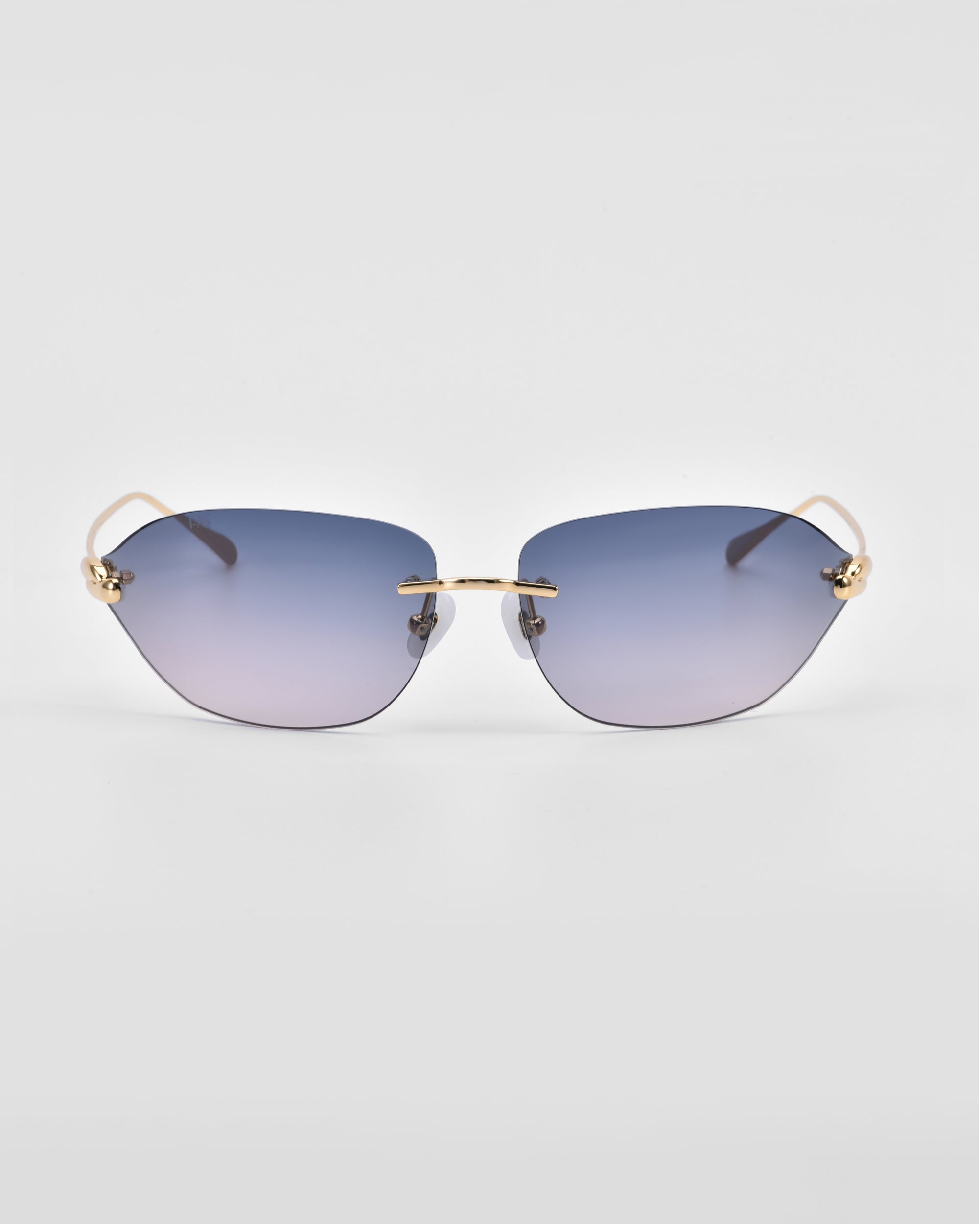 A pair of For Art&#39;s Sake® Serpent I rimless sunglasses with gradient blue-tinted lenses and 18-karat gold-plated arms and bridge. The arms have small decorative elements near the hinges. The background is plain white.