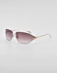 A pair of stylish For Art's Sake® Serpent I sunglasses with a bold frameless wrap lens design. They feature gradient purple lenses and sleek, 18-karat gold-plated arms. Enhanced with natural jade-stone nose pads, the Serpent I sunglasses are positioned at an angle against a plain, light grey background.