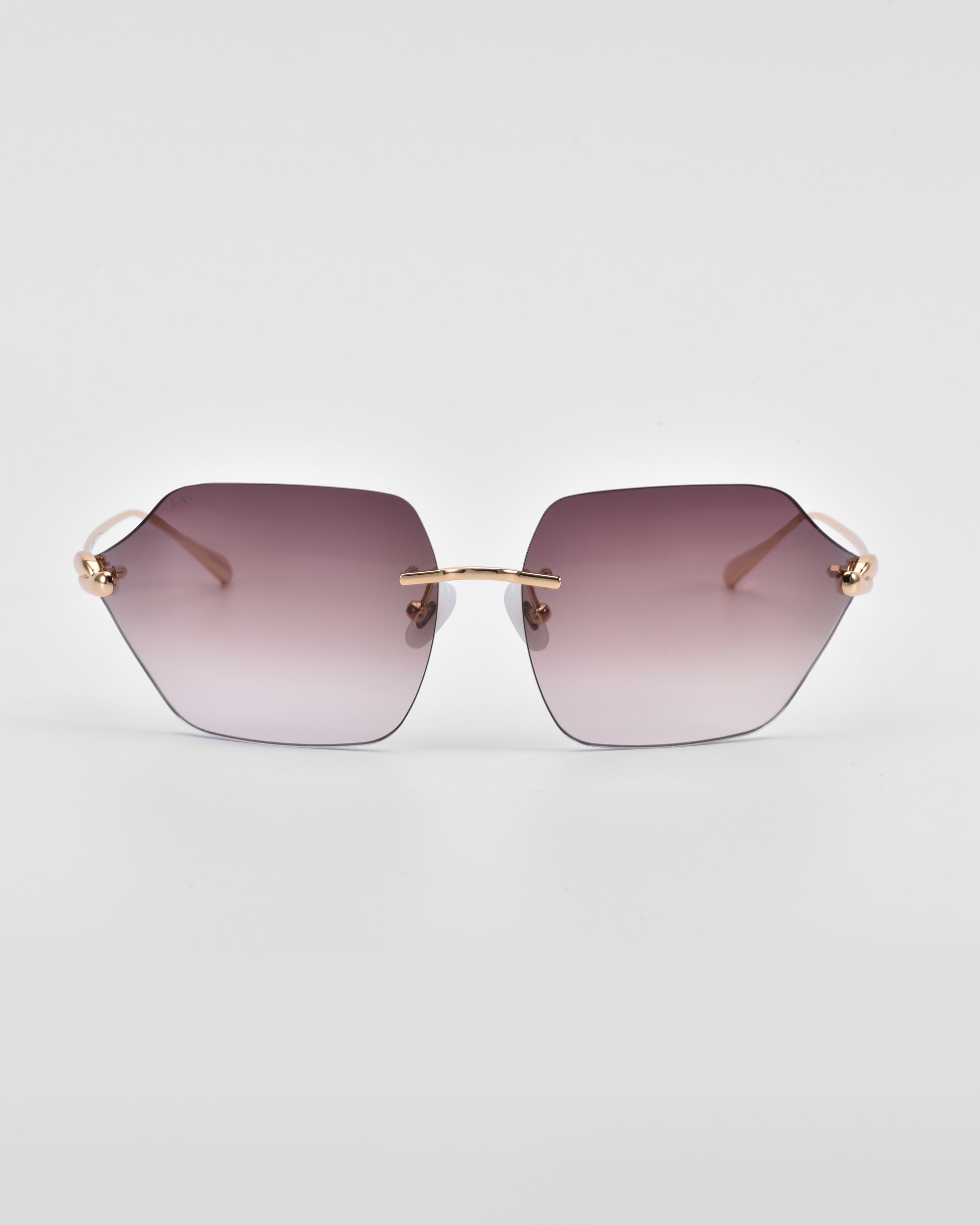 A pair of stylish, oversized hexagonal Serpent II sunglasses from For Art&#39;s Sake® with gradient lenses that transition from dark purple at the top to lighter at the bottom. The sunglasses feature 18-karat gold plating on the temples and a sleek, minimalist design. They are set against a plain white background.