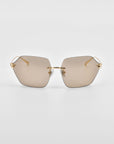 A pair of stylish Serpent II sunglasses from For Art's Sake® features a frameless wrap lens design with slightly tinted, polygonal lenses and thin, golden arms. Displayed against a plain white background, the nose bridge also boasts 18-karat gold plating, accentuating the modern design of the eyewear.