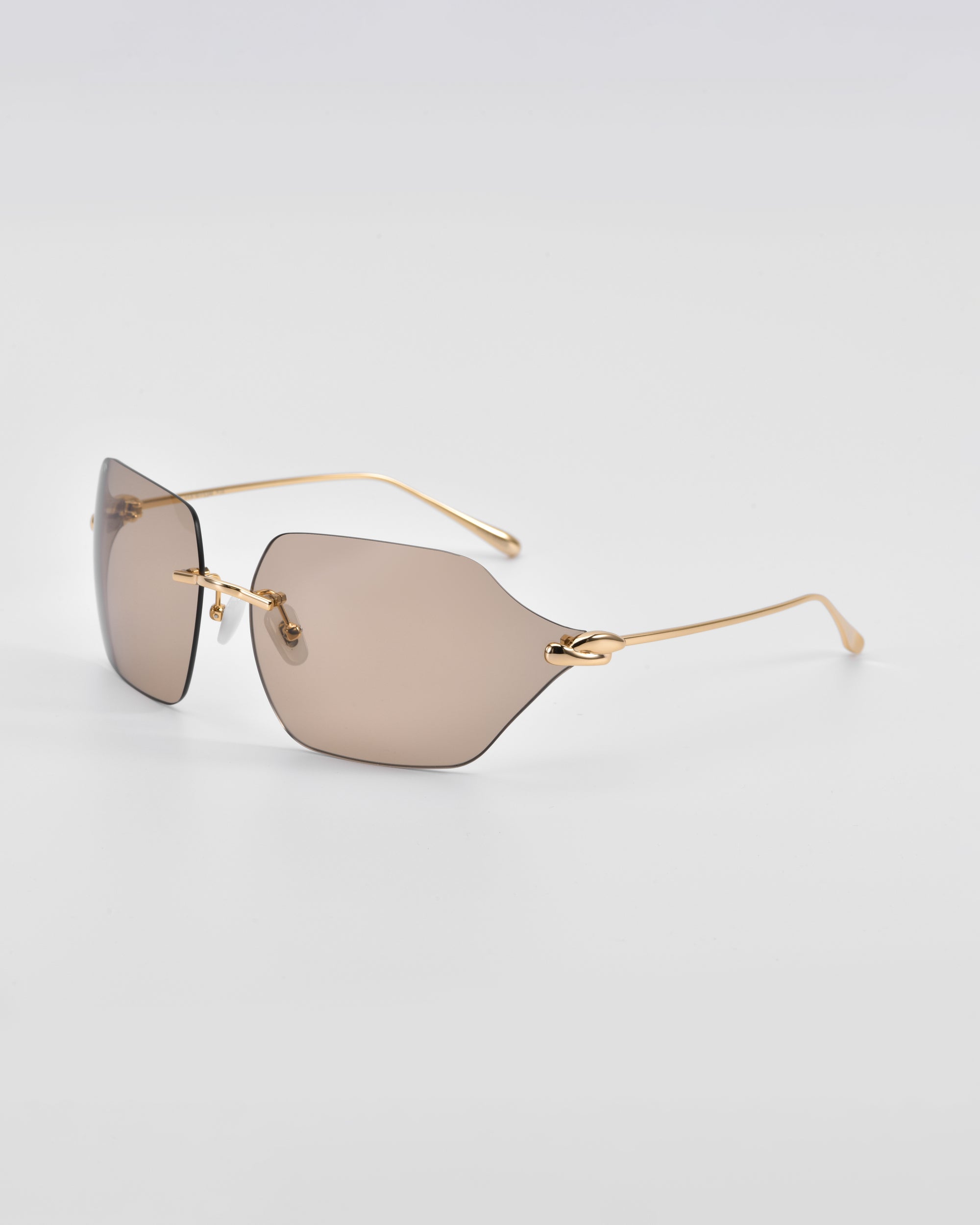 A pair of For Art&#39;s Sake® Serpent II sunglasses with rectangular, frameless wrap lens design and thin, 18-karat gold-plated arms. The brown-tinted lenses are showcased on a clean white background, highlighting their minimalist and modern aesthetic.