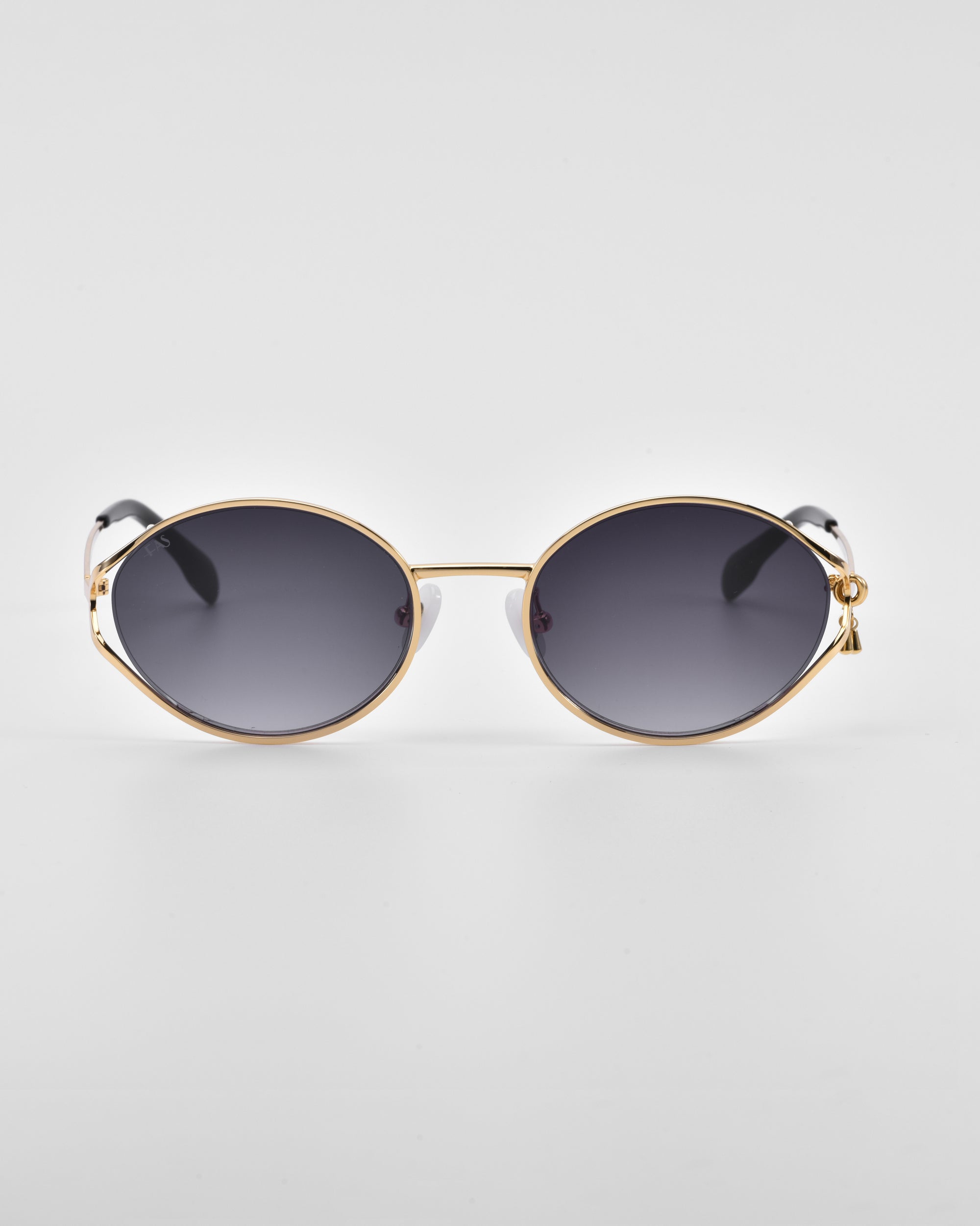 A pair of stylish Sky sunglasses by For Art's Sake® with round, dark-tinted lenses and a golden metal frame. Featuring 18-karat gold detailing and sleek, minimalist design accents, the glasses come with natural jade-stone nose pads, set against a plain white background.