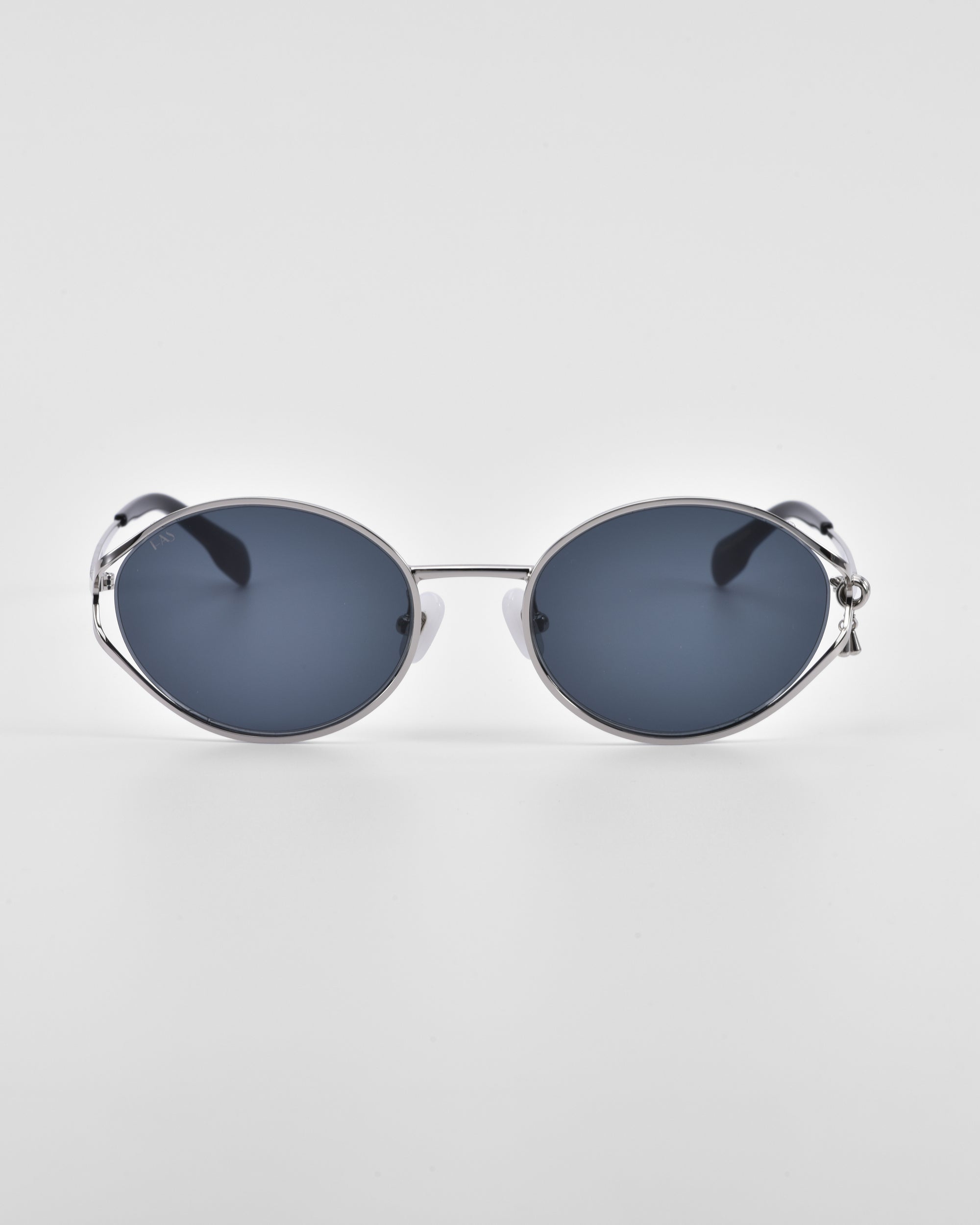 A pair of For Art&#39;s Sake® &quot;Sky&quot; sunglasses features oval-shaped, dark lenses set in a sleek silver frame, centered against a plain white background. The reflective lenses are complemented by thin, minimalist temples and natural jade-stone nose pads for added comfort and elegance.
