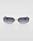 Gold-trimmed, rectangular sunglasses with dark gradient lenses against a white background. *Talia* by *For Art's Sake®* features 18-karat gold frames with unique angular design accents on the top corners and a delicate nose bridge. The temples are thick and blend into black tips.