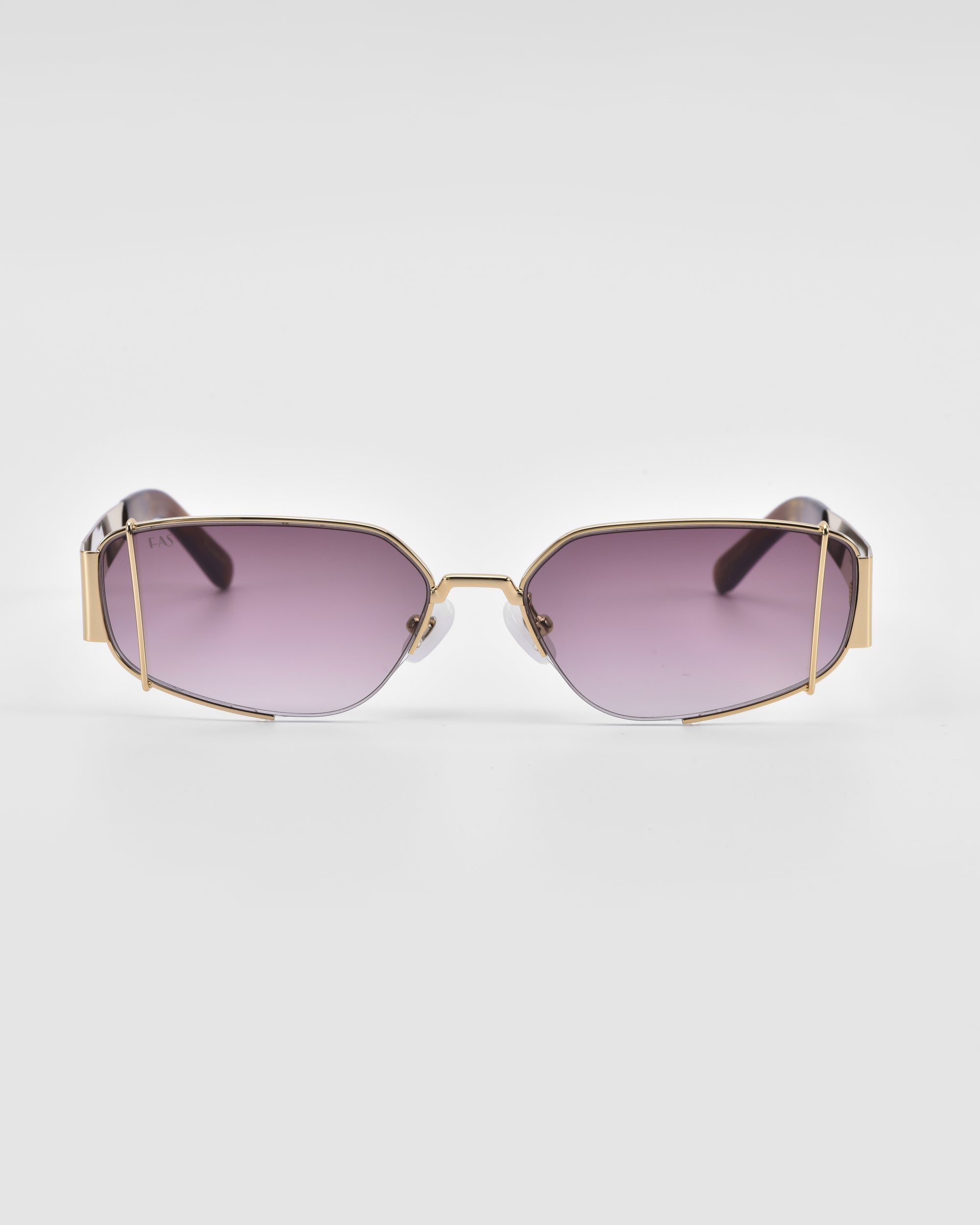 A pair of For Art's Sake® Talia sunglasses with purple-tinted lenses and a unique geometric metal frame. The frame, finished in 18-karat gold, features an angular design, giving the sunglasses a modern and edgy look. The background is plain white.