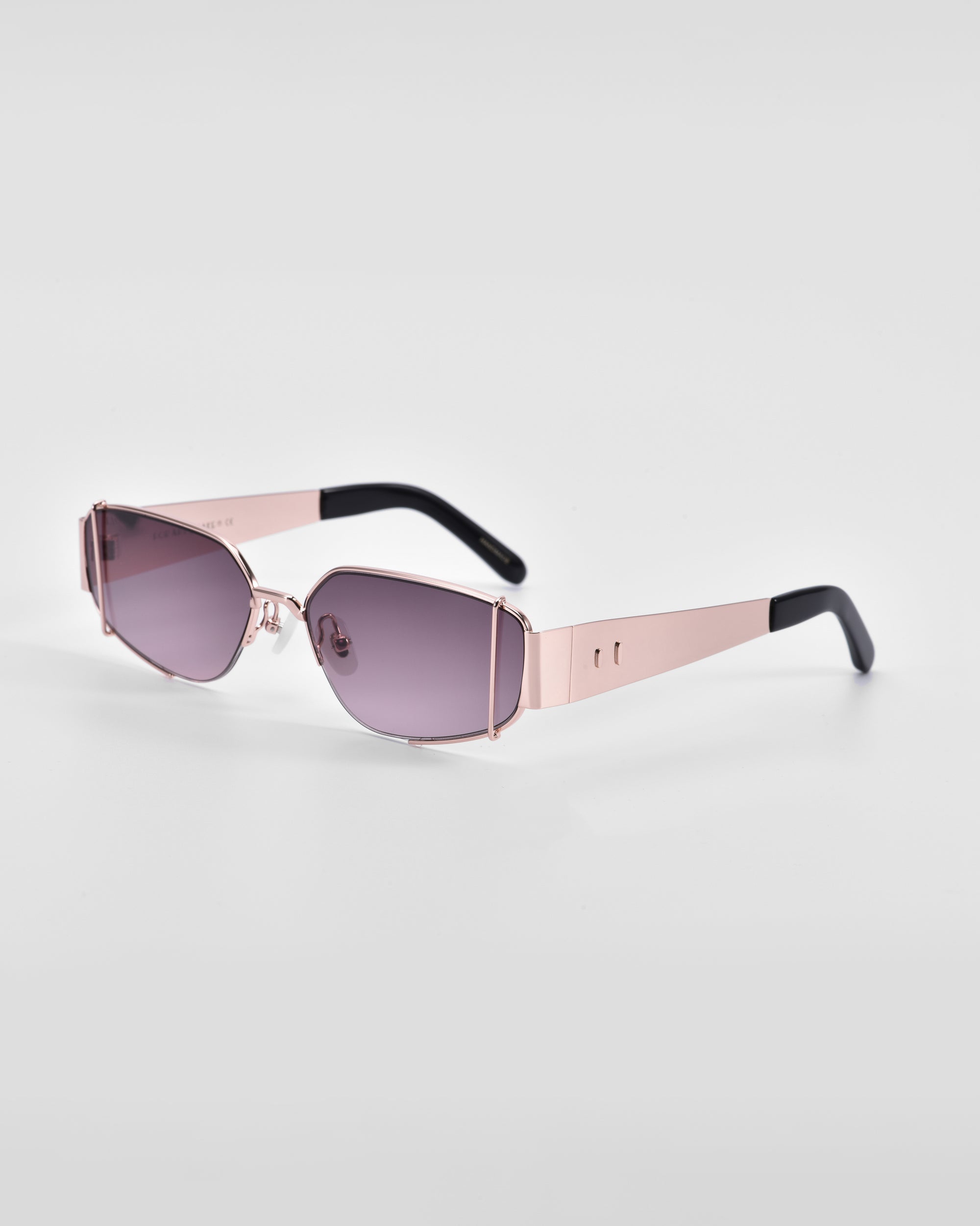 A pair of stylish sunglasses featuring rectangular, purple-tinted lenses and stunning 18-karat gold metal frames with black temple tips. The design is modern and sleek with thin, minimalist arms and clean lines, set against a plain white background. Presenting the Talia from For Art&#39;s Sake®.