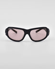 A pair of black-framed For Art's Sake® Raven sunglasses with tinted lenses is shown against a plain white background. The design features a sleek, angular shape with slightly rounded edges, and the lenses appear to have a subtle pinkish tint.