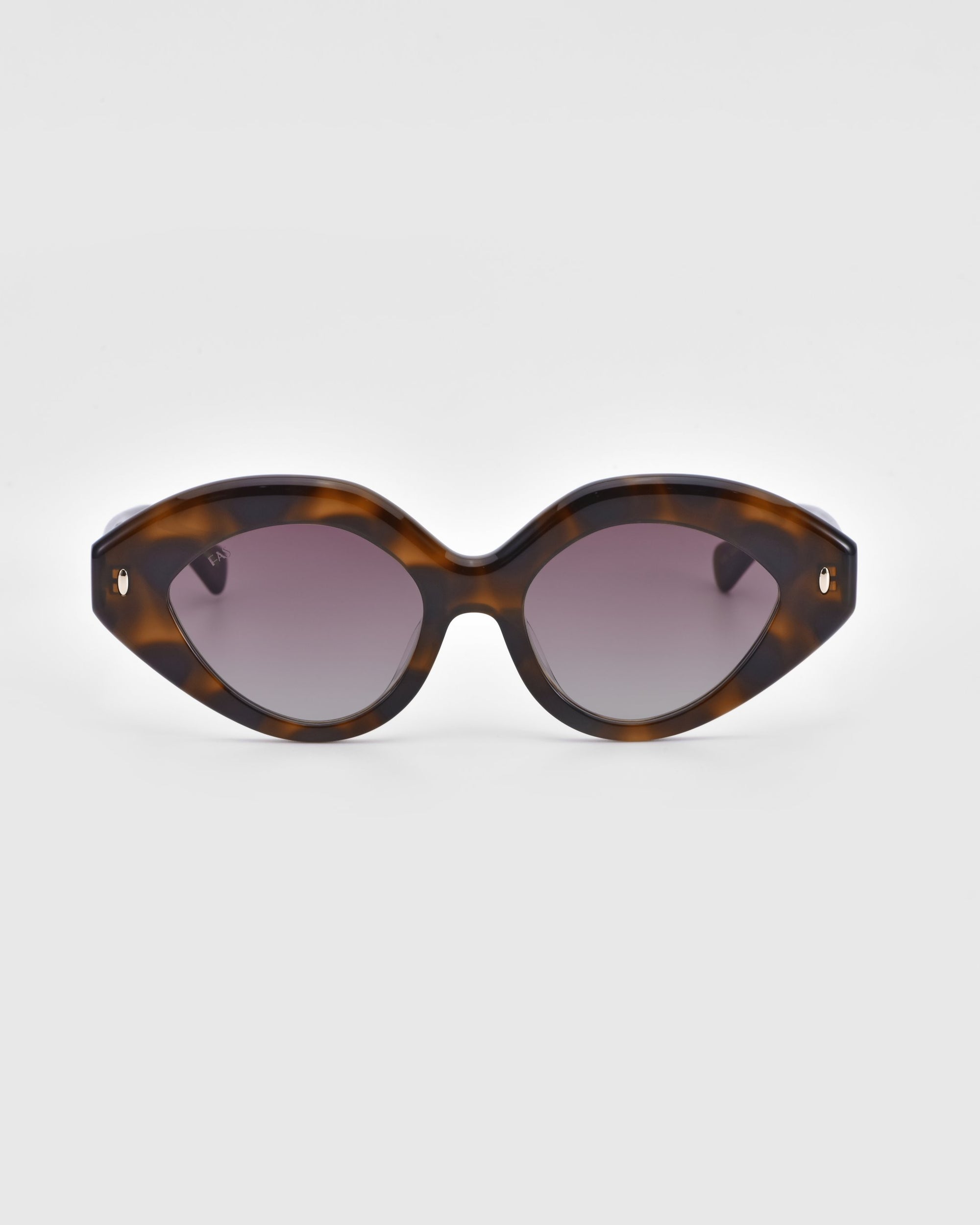 A pair of brown tortoiseshell Vera sunglasses by For Art&#39;s Sake® with an elegant cat-eye silhouette and dark tinted lenses. Photographed against a plain white background, the biodegradable acetate frame extends gracefully to the sides.