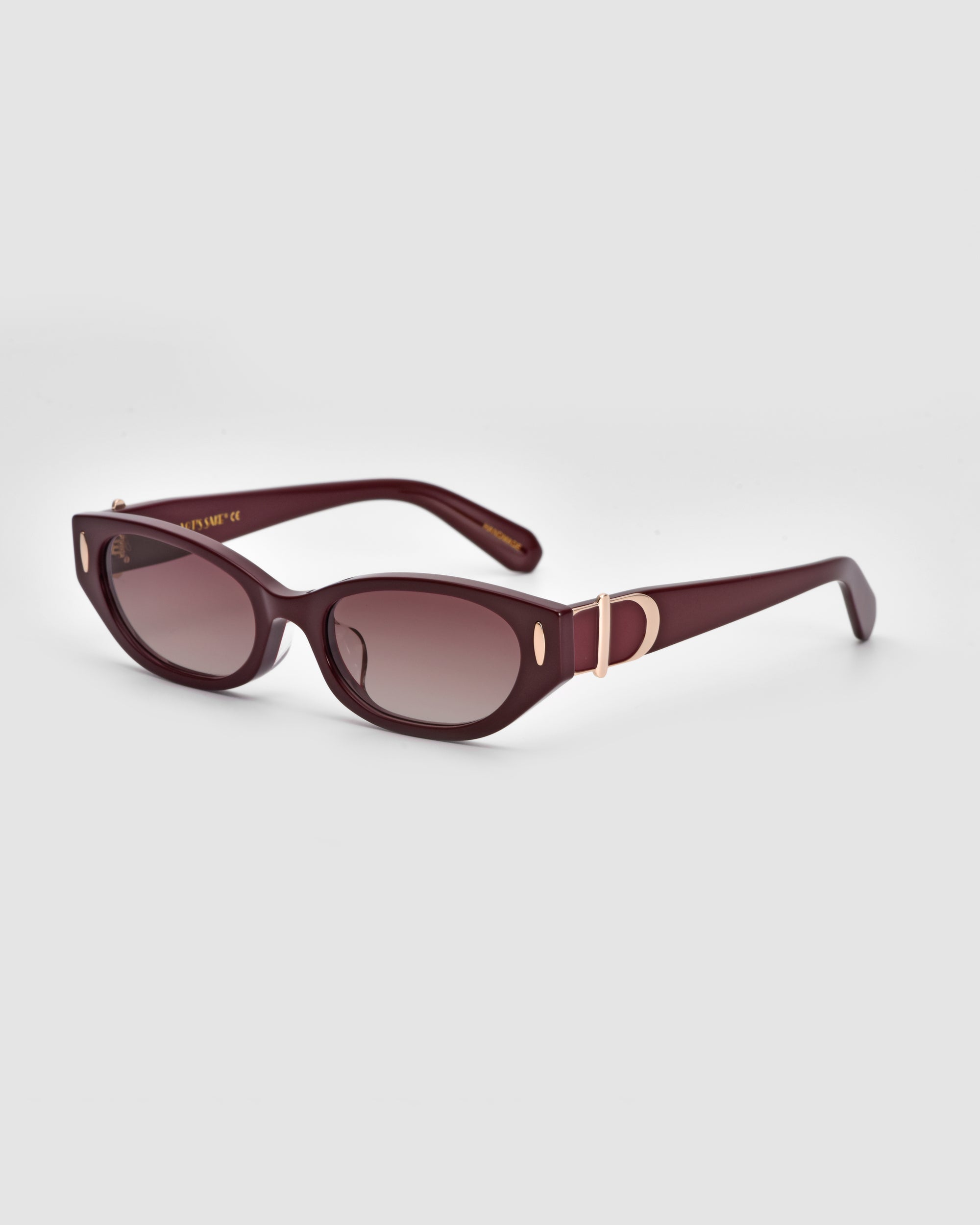 A pair of For Art's Sake® Skinny Latte sunglasses featuring dark red, rectangular frames and tinted lenses. The design is minimalist with a small metallic accent on the arms near the hinges. They are displayed against a plain white background.