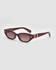 A pair of For Art's Sake® Skinny Latte sunglasses featuring dark red, rectangular frames and tinted lenses. The design is minimalist with a small metallic accent on the arms near the hinges. They are displayed against a plain white background.