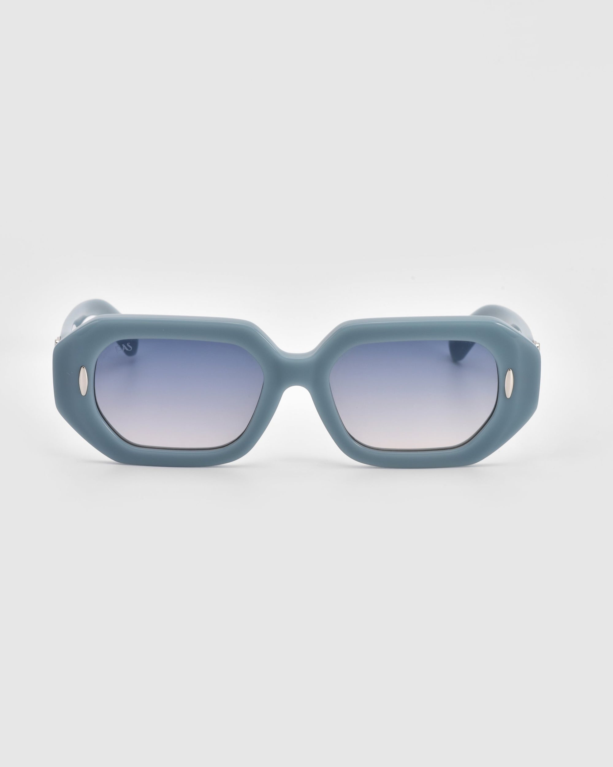 A chic pair of For Art's Sake® Vitamin D sunglasses featuring fashionable rectangular frames made of matte teal, biodegradable acetate. The gradient lenses transition smoothly from dark at the top to lighter at the bottom, and small oval accents on the temples near the lens frames add a stylish touch.