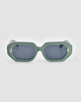 A pair of oversized For Art's Sake® Vitamin D sunglasses with thick, green rectangular frames and dark lenses. The temples feature small gold oval accents near the hinges, adding a touch of elegance. Made from stainless steel and biodegradable acetate, these stylish sunglasses are as eco-friendly as they are fashionable.