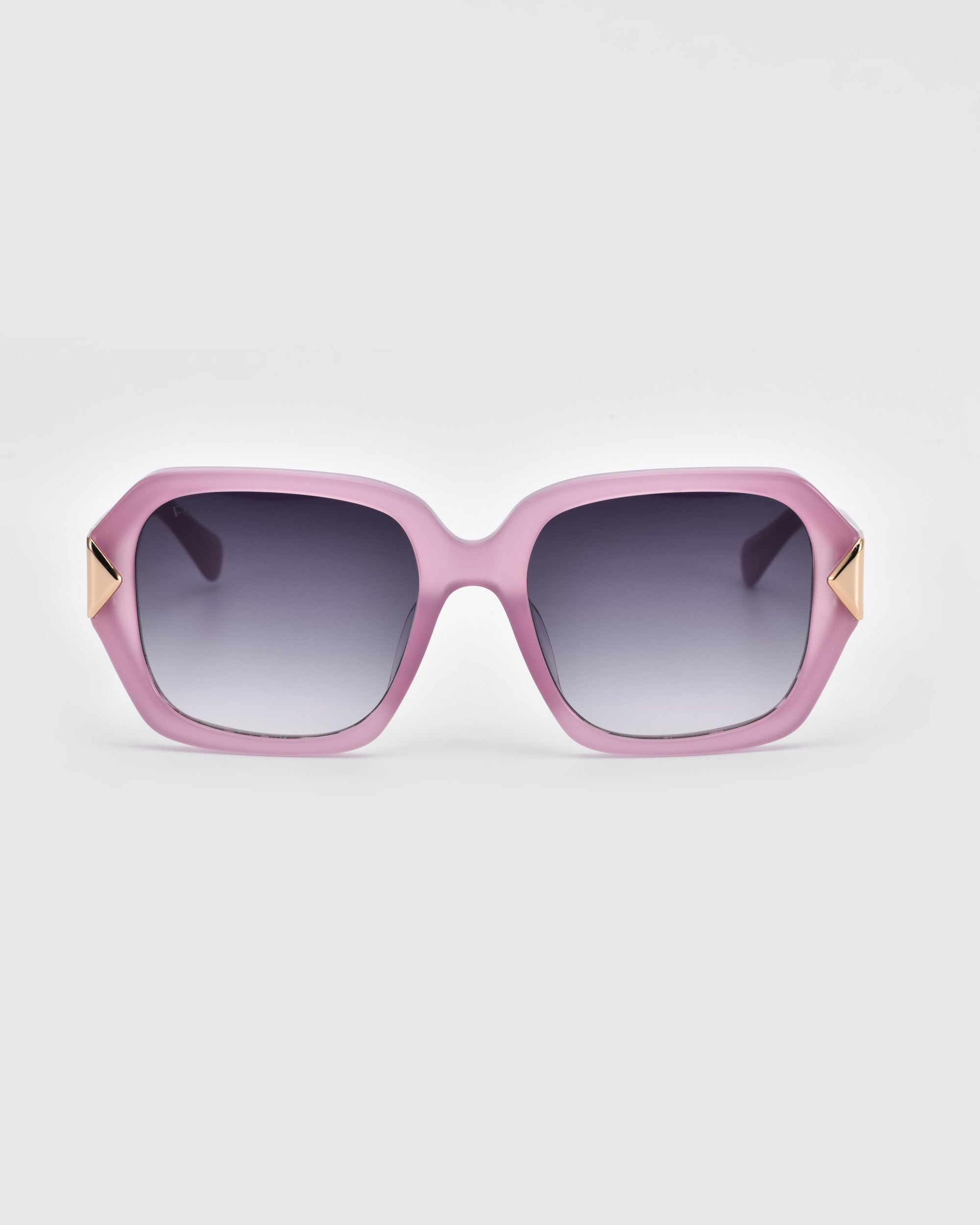 Introducing Frankie by For Art&#39;s Sake®: a pair of oversized geometric sunglasses featuring thick, chunky acetate frames in a striking pink color with gradient lenses. The temples are adorned with small triangular gold accents near the hinges, set against a plain white background.