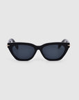 Introducing the Bonbon sunglasses by For Art's Sake®: a chic pair of black cat-eye silhouette sunglasses with dark tinted lenses. These glossy frames boast a sleek design, highlighted by thin, slightly curved arms. Set against a minimal light grey background to underscore the elegance of the Bonbon model.