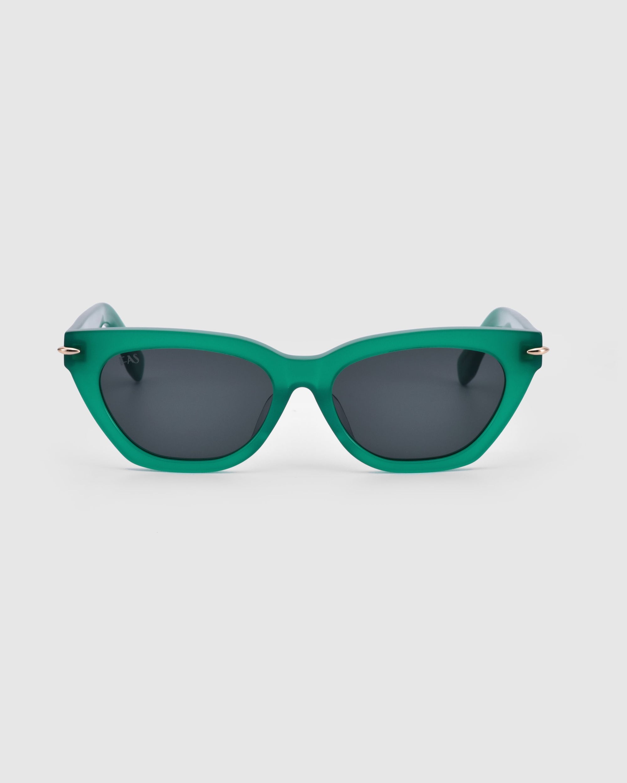 A pair of green rectangular Bonbon sunglasses from For Art&#39;s Sake® featuring dark lenses. The solid green frames include a slightly raised bridge, with matching color arms for a cohesive appearance. The background is plain and white.