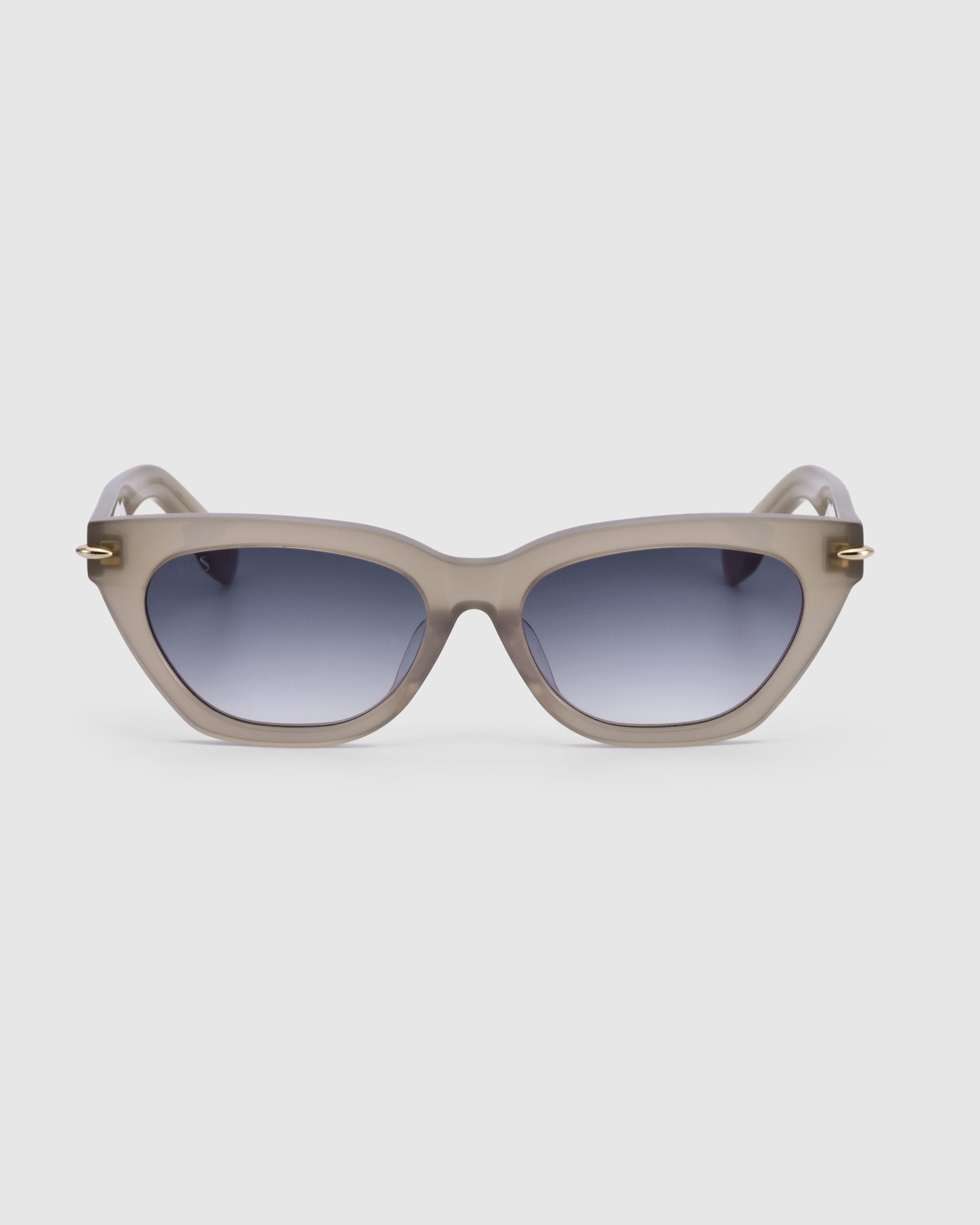 A pair of For Art&#39;s Sake® Bonbon sunglasses featuring a subtle blend of cat-eye silhouette and rectangular shape. They come with a light gray frame and dark tinted lenses, boasting a smooth, glossy finish with small gold accents near the hinges on each side, set against a plain white background.