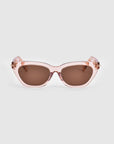 A pair of stylish pink Bonbon sunglasses by For Art's Sake®, featuring dark brown lenses, is shown against a plain white background. The thick frame has a shiny finish and showcases a subtle cat-eye silhouette.