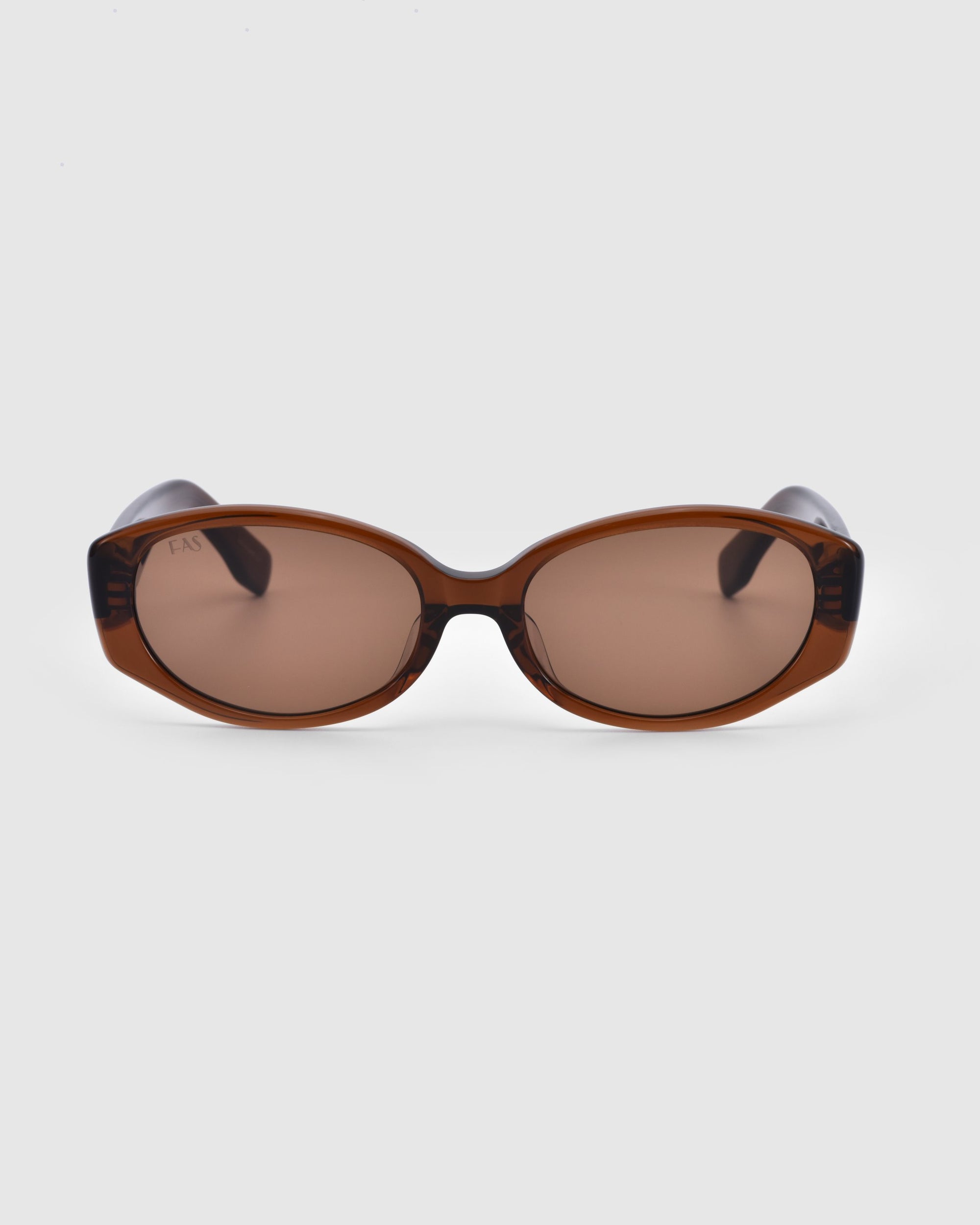 A pair of geometric eyewear with dark brown lenses and a matching frame, these Friday sunglasses by For Art's Sake® are positioned facing forward against a plain gray background, offering both style and UV protection.