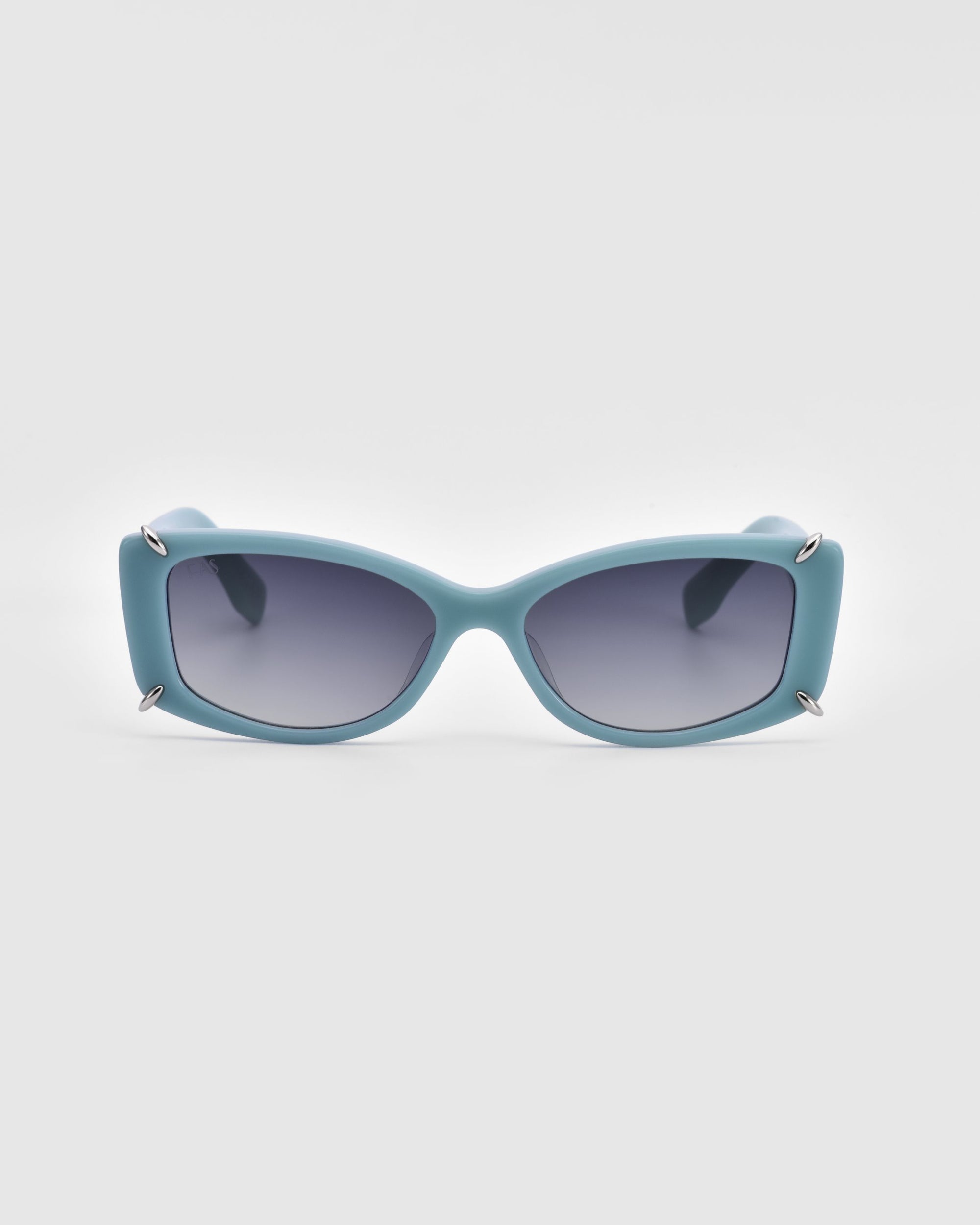 For Art's Sake® presents the Dyer sunglasses, featuring a modern design with teal-colored frames and rectangular lenses. These luxurious sunglasses include silver accents on the corners and tinted dark lenses that offer UV protection. The frames boast a slightly curved design, perfectly blending style and sustainability.