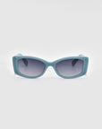 For Art's Sake® presents the Dyer sunglasses, featuring a modern design with teal-colored frames and rectangular lenses. These luxurious sunglasses include silver accents on the corners and tinted dark lenses that offer UV protection. The frames boast a slightly curved design, perfectly blending style and sustainability.