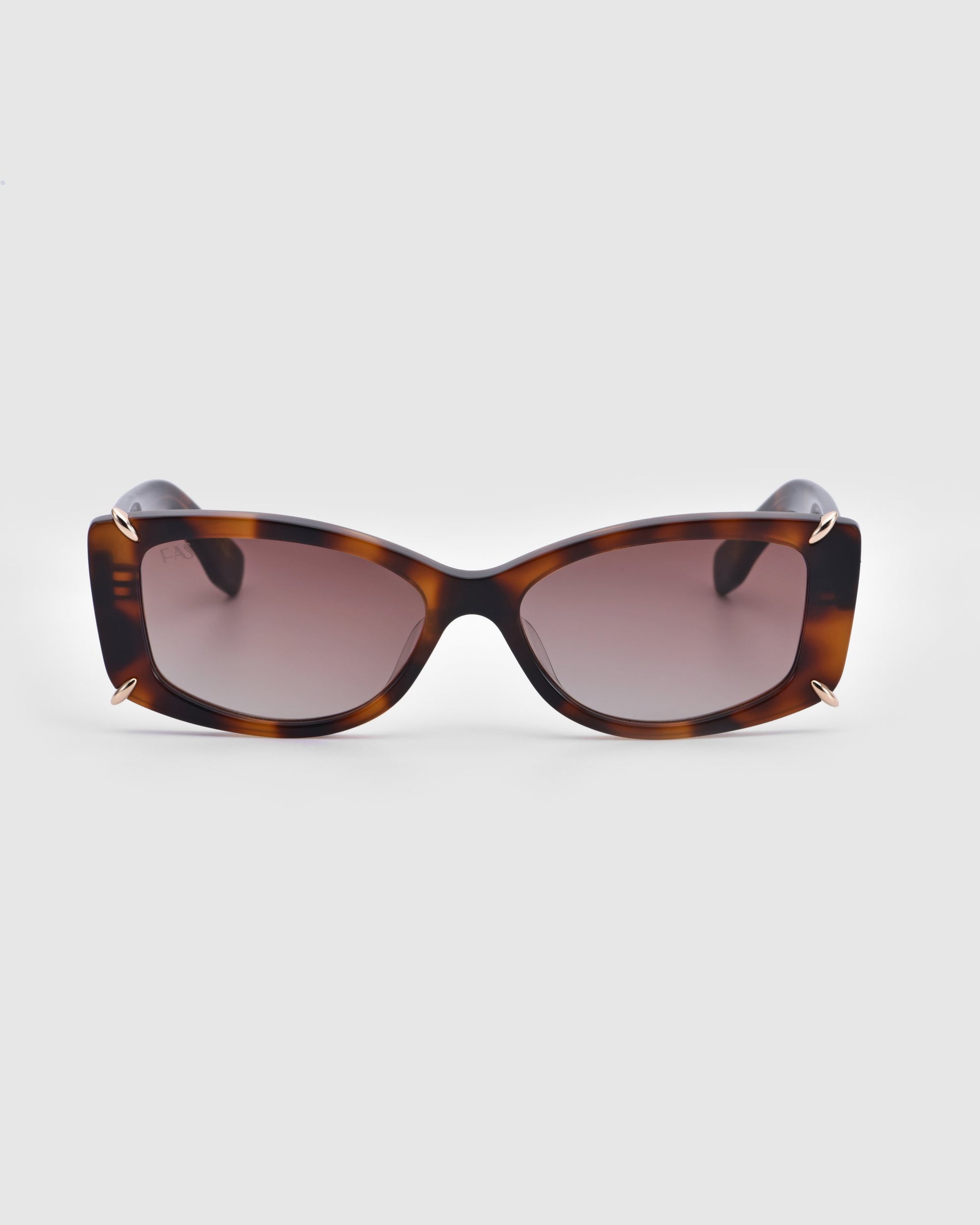 A pair of rectangular Dyer sunglasses from For Art's Sake®, featuring tortoiseshell-patterned frames with a sophisticated blend of brown and black hues, as well as dark lenses for premium UV protection, are showcased against a plain white background. These stylish and sleek sunglasses are perfect for luxury and sustainability-conscious consumers.