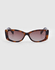 A pair of rectangular Dyer sunglasses from For Art's Sake®, featuring tortoiseshell-patterned frames with a sophisticated blend of brown and black hues, as well as dark lenses for premium UV protection, are showcased against a plain white background. These stylish and sleek sunglasses are perfect for luxury and sustainability-conscious consumers.