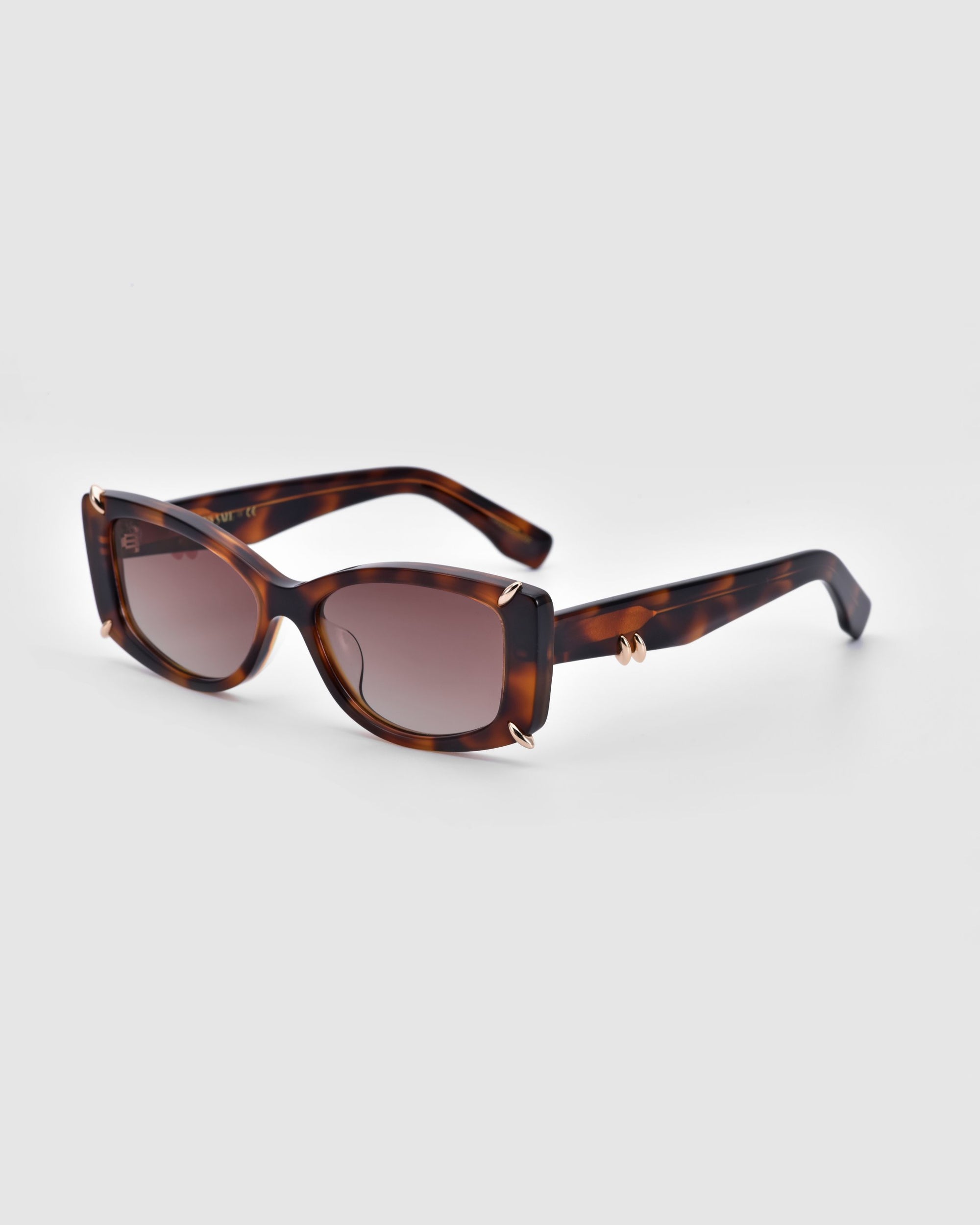 Explore the Dyer sunglasses by For Art's Sake®: sophisticated tortoiseshell rectangular frames with dark tinted lenses that provide UV protection. These luxurious shades feature a subtly curved design and elegant gold accents where the arms connect. The thick arms maintain a consistent tortoiseshell pattern, merging style with sustainability.