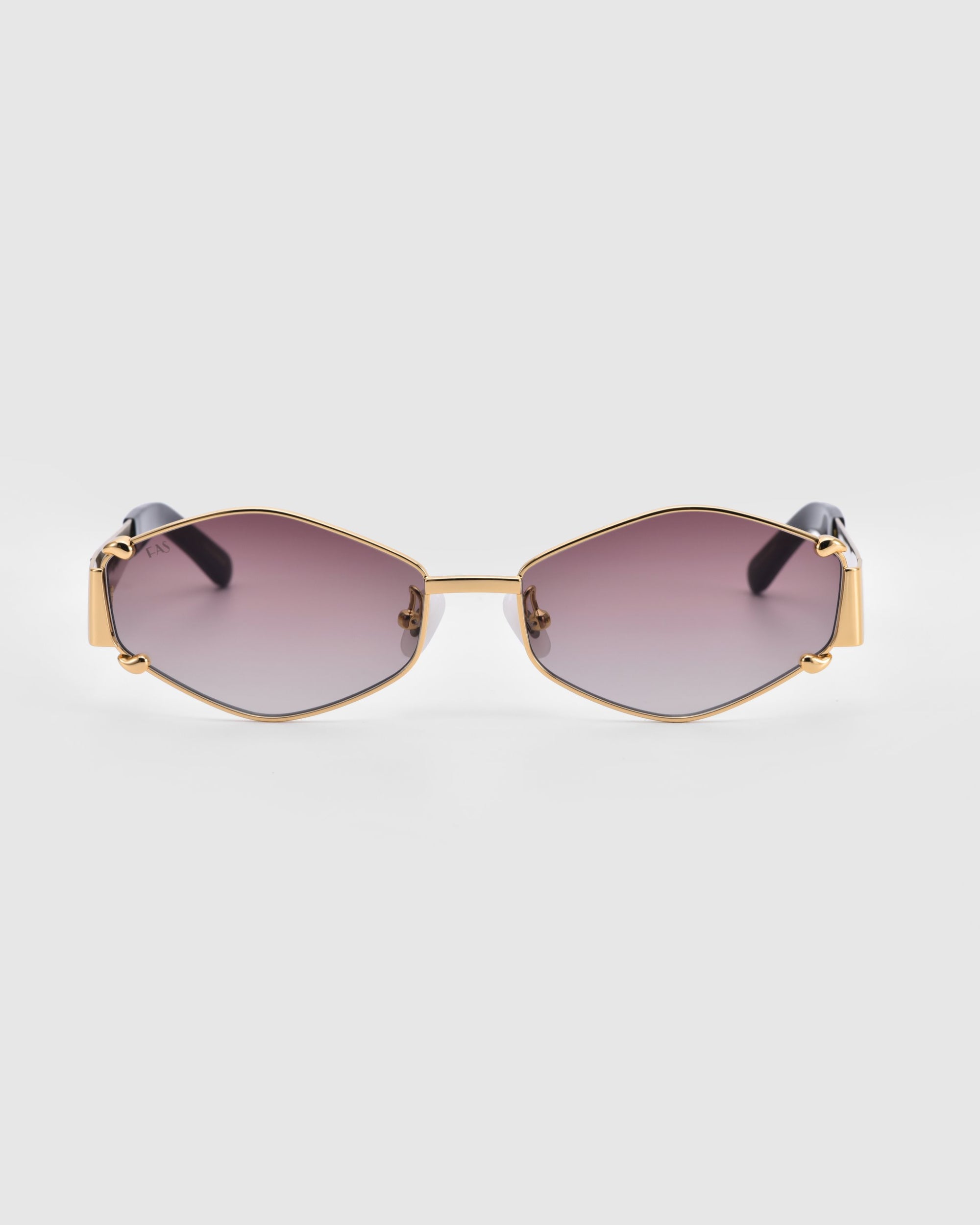 A pair of luxury Empress sunglasses by For Art's Sake® with geometric, gold frames and dark gradient lenses. These sunglasses feature unique angles, UV protection, and a sleek, modern look.