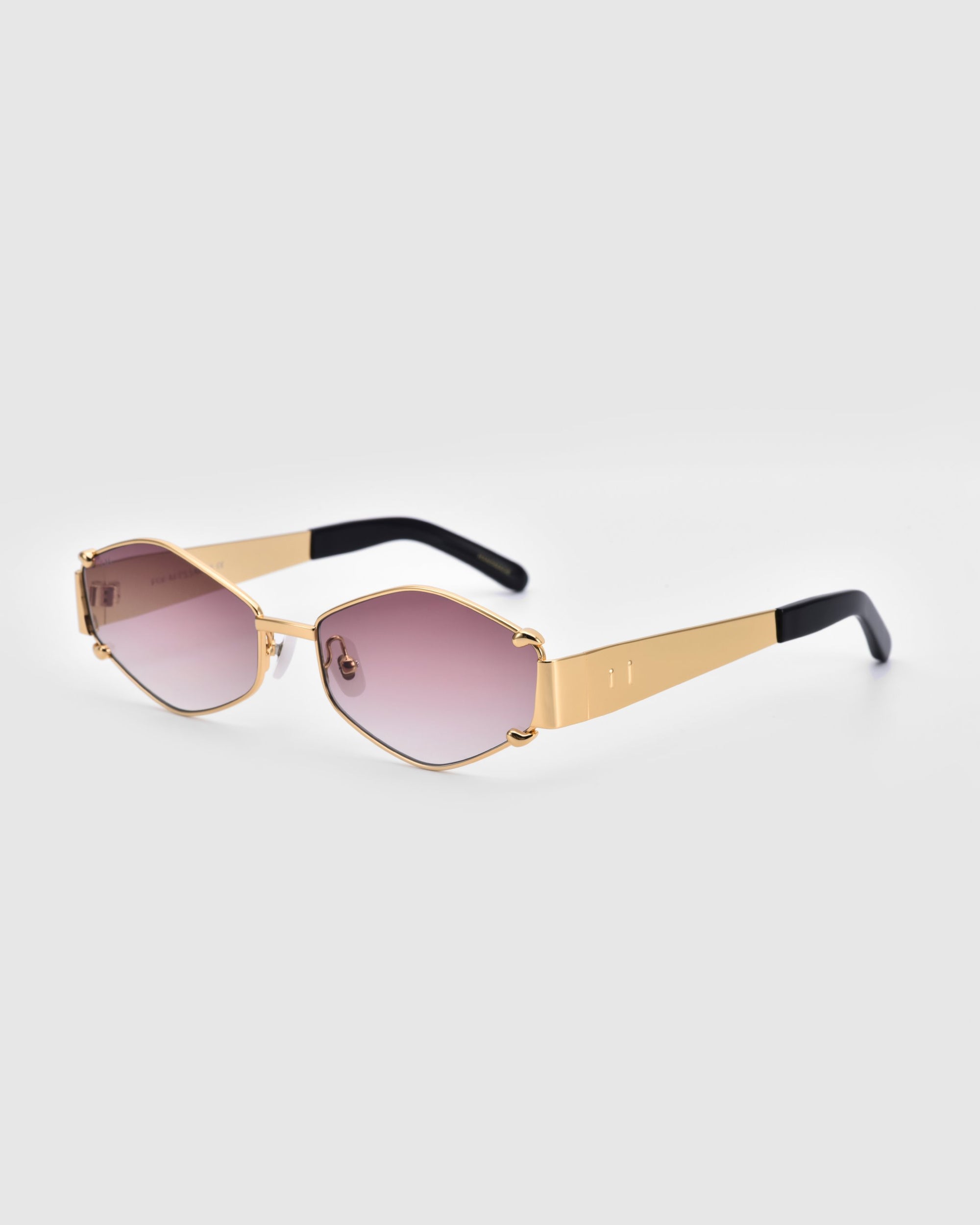 The &quot;Empress&quot; by For Art&#39;s Sake® is a pair of luxury sunglasses featuring hexagonal gradient lenses that transition from pink at the bottom to clear at the top. The oversized frame is gold with black temples, blending modern geometric lines with a touch of elegance and essential UV protection.