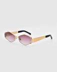 The "Empress" by For Art's Sake® is a pair of luxury sunglasses featuring hexagonal gradient lenses that transition from pink at the bottom to clear at the top. The oversized frame is gold with black temples, blending modern geometric lines with a touch of elegance and essential UV protection.