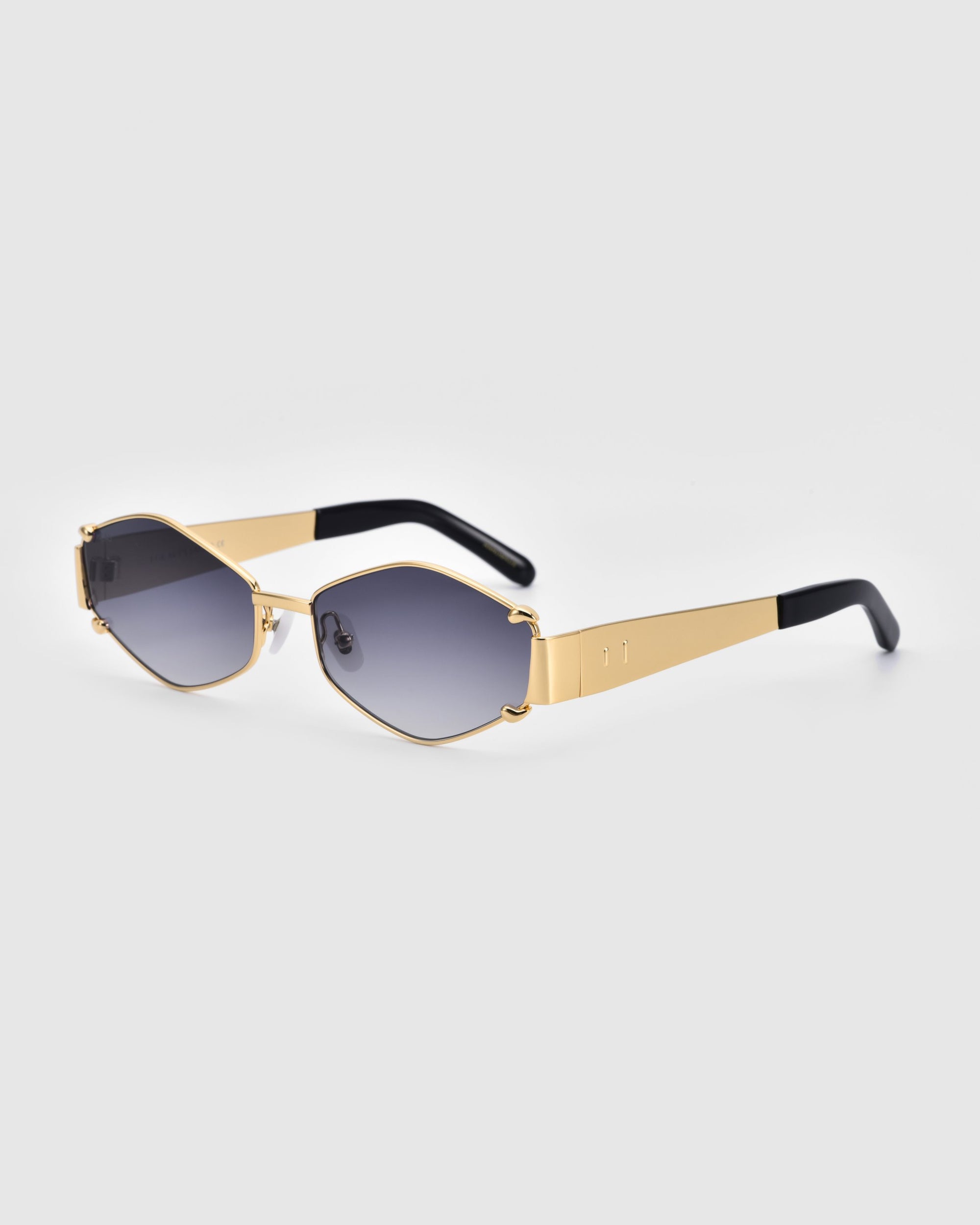 A pair of Empress luxury sunglasses by For Art's Sake® with gold-colored frames and dark, rectangular lenses is pictured against a plain white background. The temples are primarily gold, with black tips. The design is modern and sleek, offering both style and UV protection for your eyes.