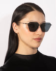 A person with long, straight black hair is wearing large, rectangular Cece sunglasses from For Art's Sake® with gradient lenses and a black top. They are facing slightly to the right, against a plain white background.