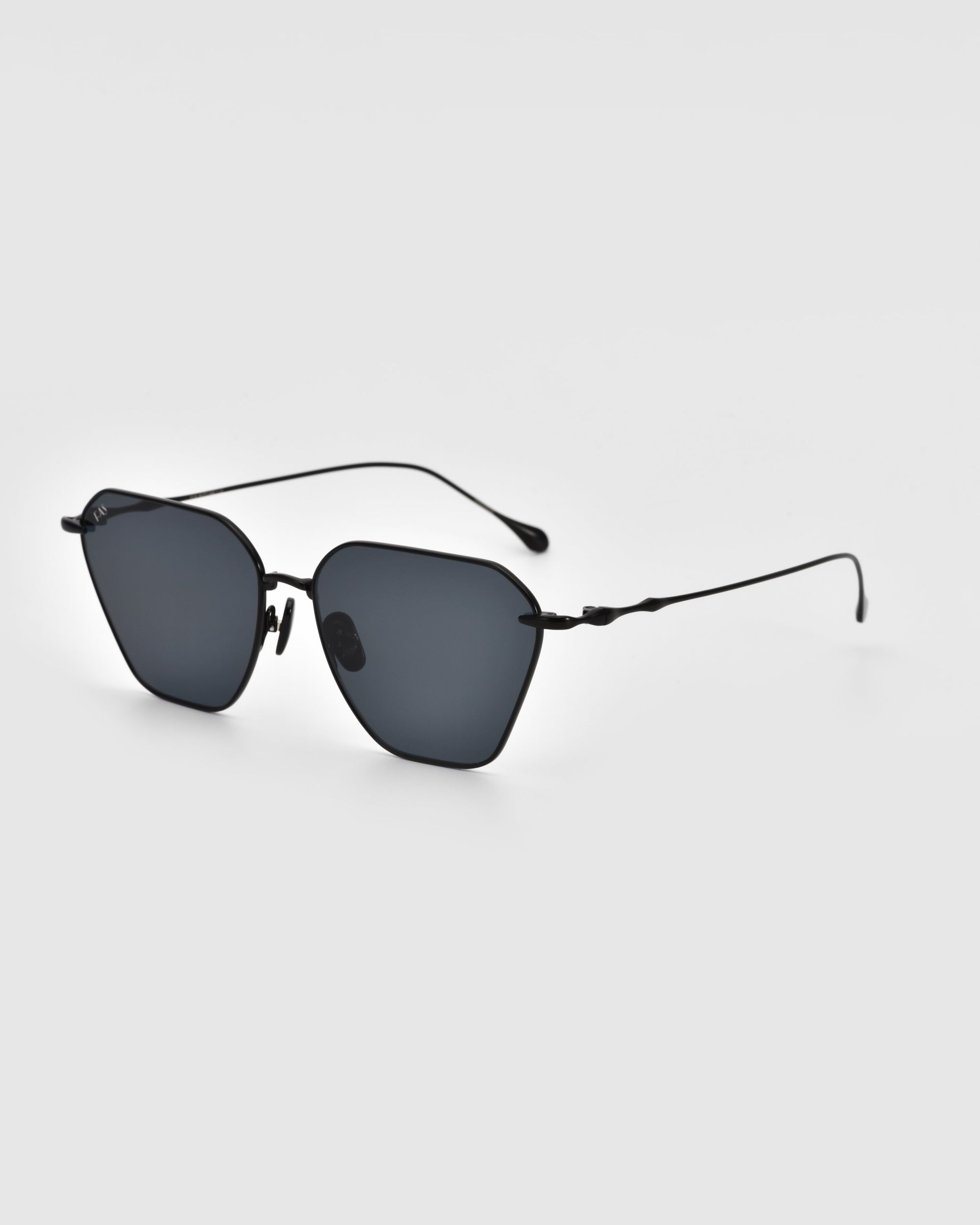 A pair of For Art&#39;s Sake® Cece sunglasses featuring thin, black metal frames and dark, rectangular lenses, showcased on a plain, light grey background. These stylish sunglasses come equipped with comfortable nose pads and slightly curved earpieces.