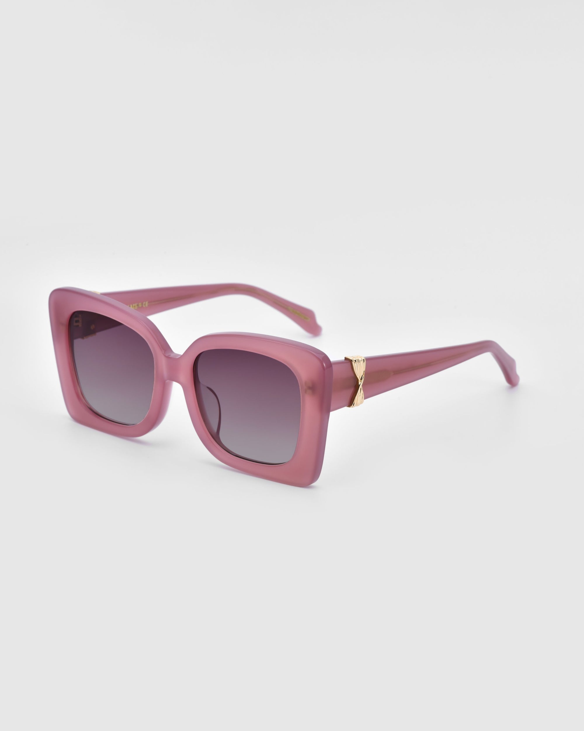 A pair of stylish For Art's Sake® Ribbon Sunglasses with oversized, square-shaped frames in a pink hue. The sunglasses feature dark tinted lenses and gold accents on the arms near the hinges. These sustainable sunglasses are set against a plain white background.