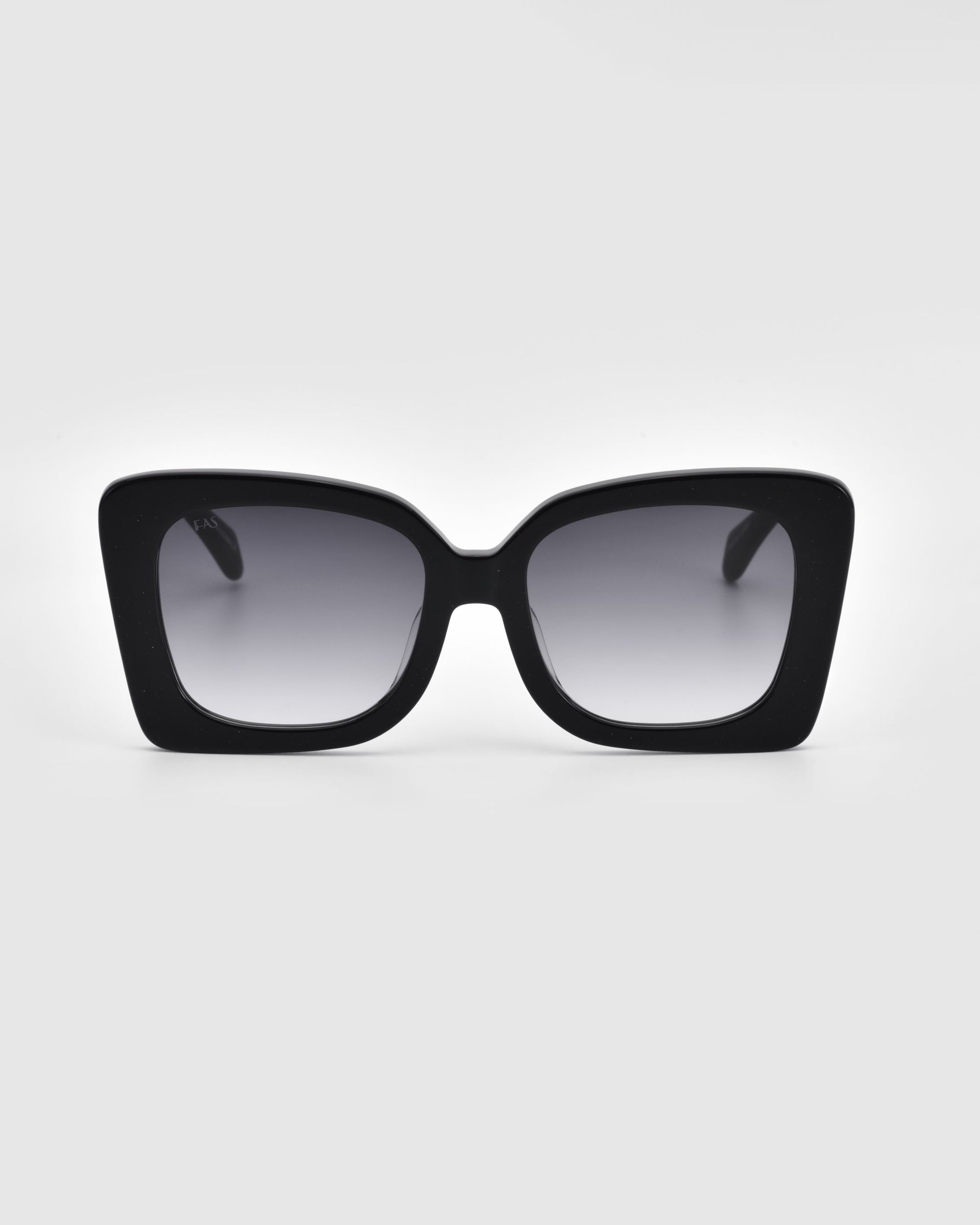 A pair of Ribbon sunglasses from For Art&#39;s Sake®, these black oversized square frames with dark gradient lenses make a stylish accessory against a plain white background.