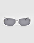 These Rose Garden rimless sunglasses from For Art's Sake® feature rectangular gray lenses and thin silver arms adorned with decorative metal details near the hinges, reminiscent of sculpted rose ornaments.