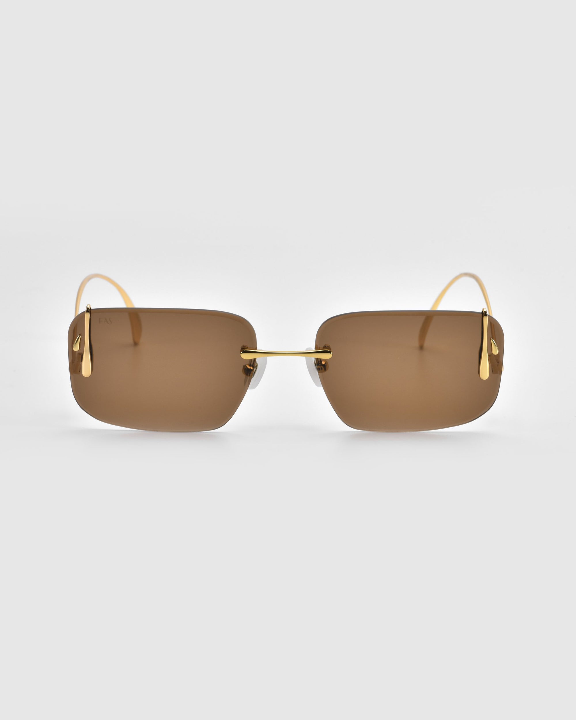 For Art's Sake® Vermilion sunglasses feature square brown lenses with gold rims and thin gold temples, adding an artistic flair. They are set against a plain light gray background.