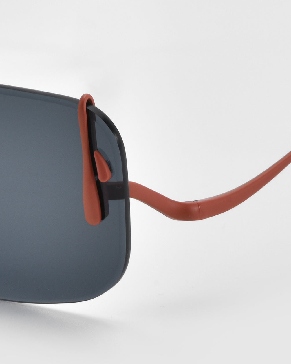 Close-up of For Art's Sake® Vermilion sunglasses, showcasing rectangular dark lenses and slim red-brown temples with distinctive dripping metal accents, set against a white background.