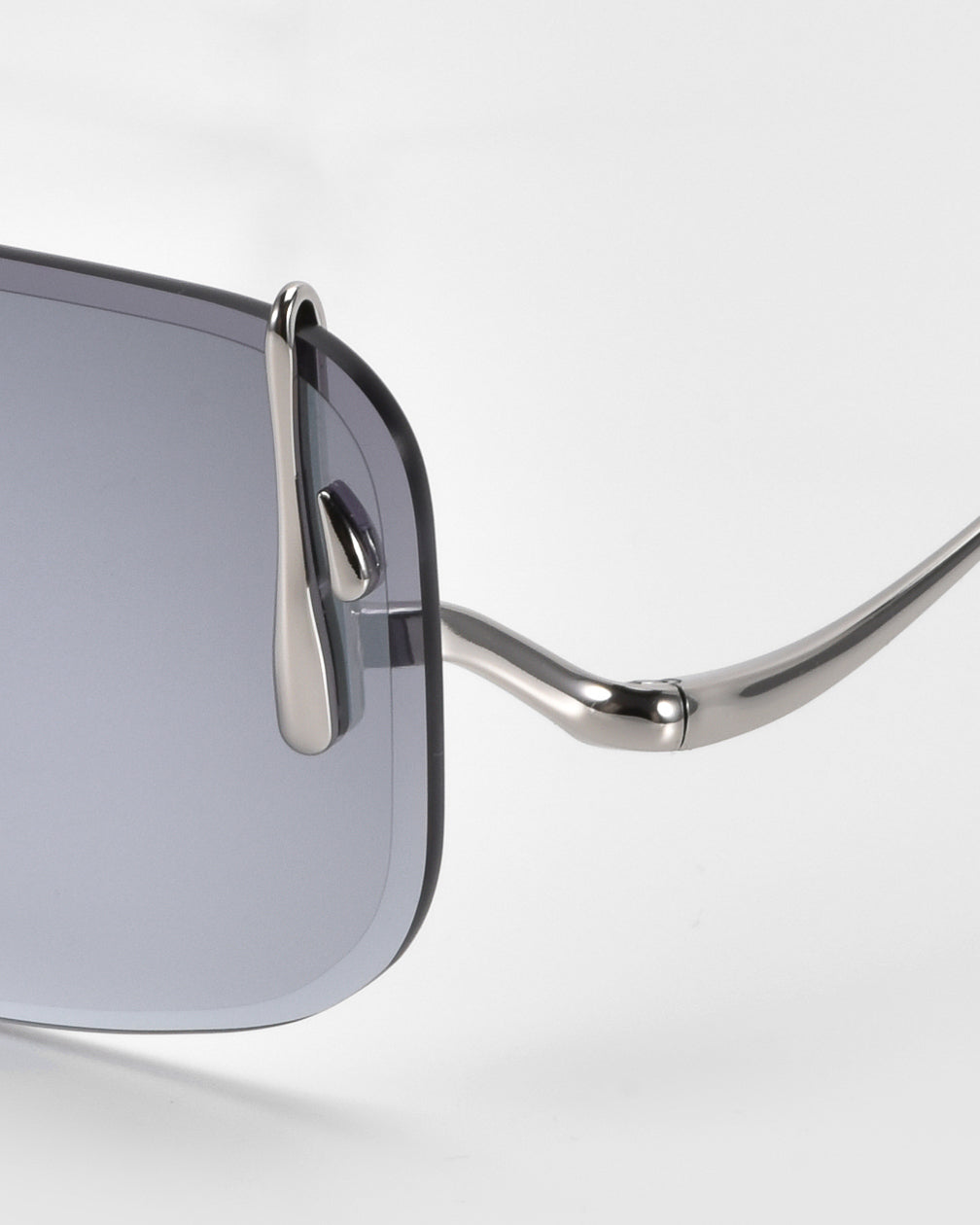 The Vermilion sunglasses by For Art's Sake® showcase a stylish metal frame and dark tinted lenses. Notable are the curved arms with dripping metal accents, highlighting their shiny finish against a plain background.