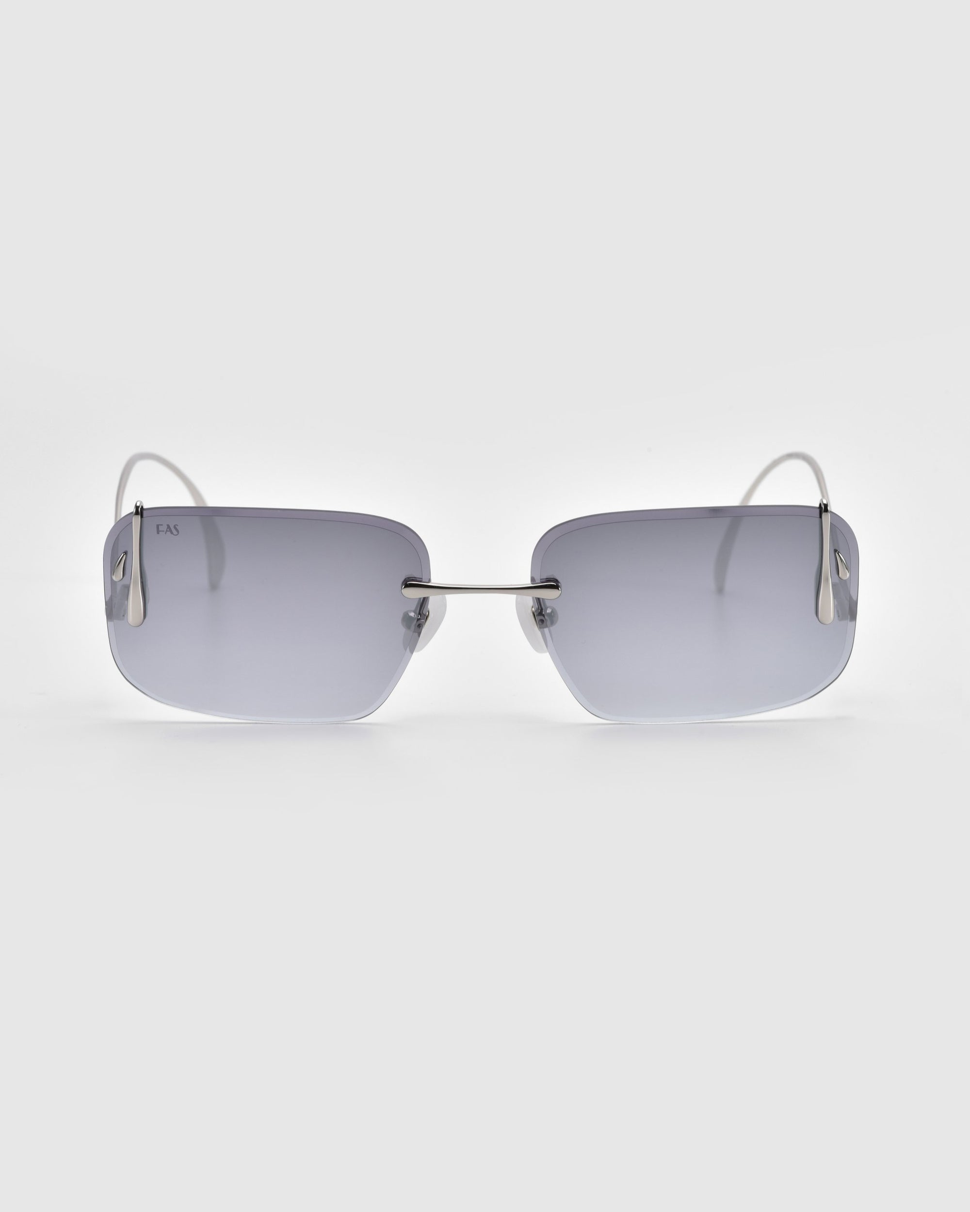 The Vermilion sunglasses by For Art's Sake® feature a sleek rimless design with rectangular grey lenses and thin metal arms. The lenses attach directly to sculptural temples, creating an elegant silhouette against a plain light grey background.