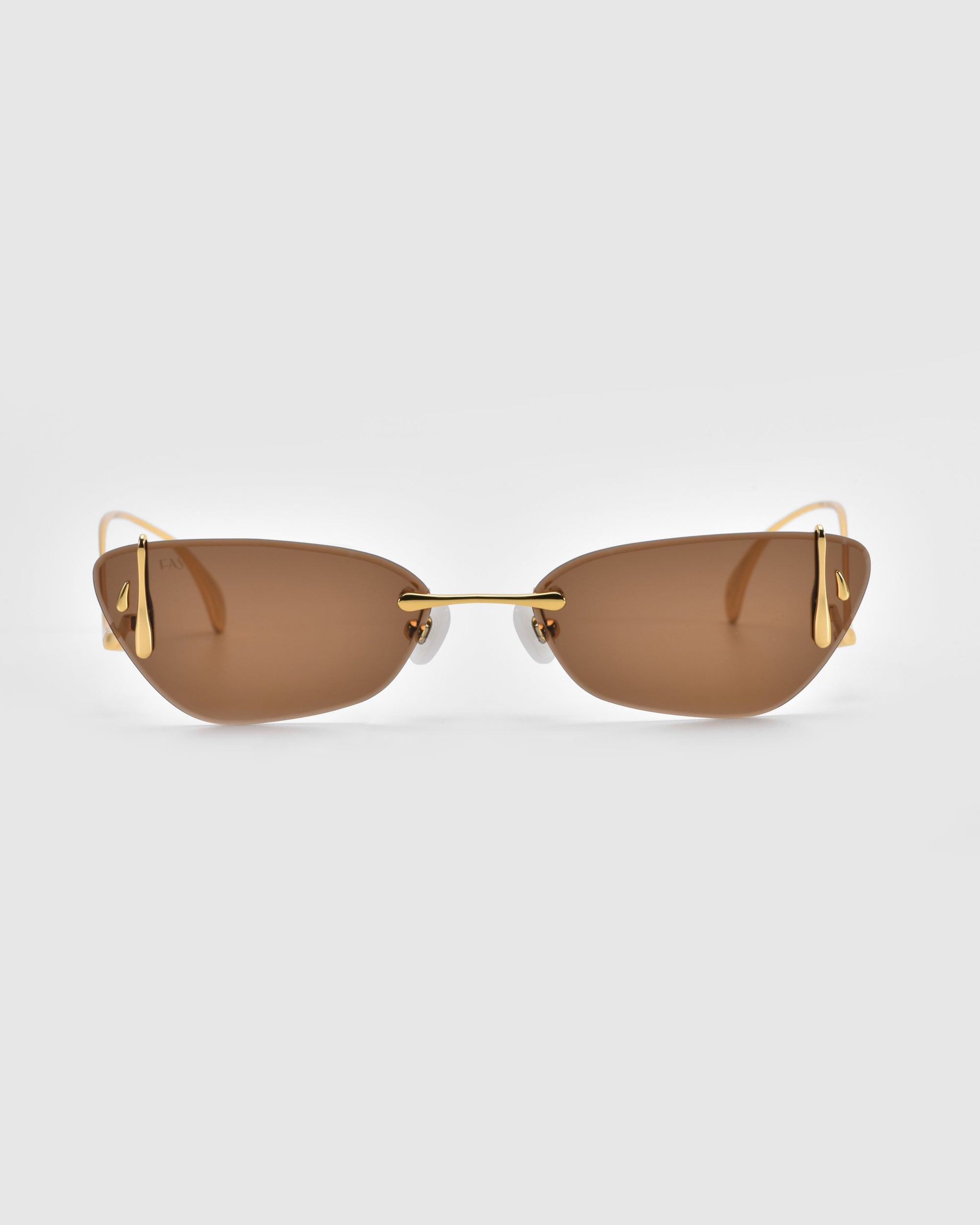 Part of the Rose Garden Collection, For Art's Sake® introduces Crimson—a pair of sleek rimless sunglasses with elegant brown-tinted lenses and gold-toned temples, set against a plain light gray background.