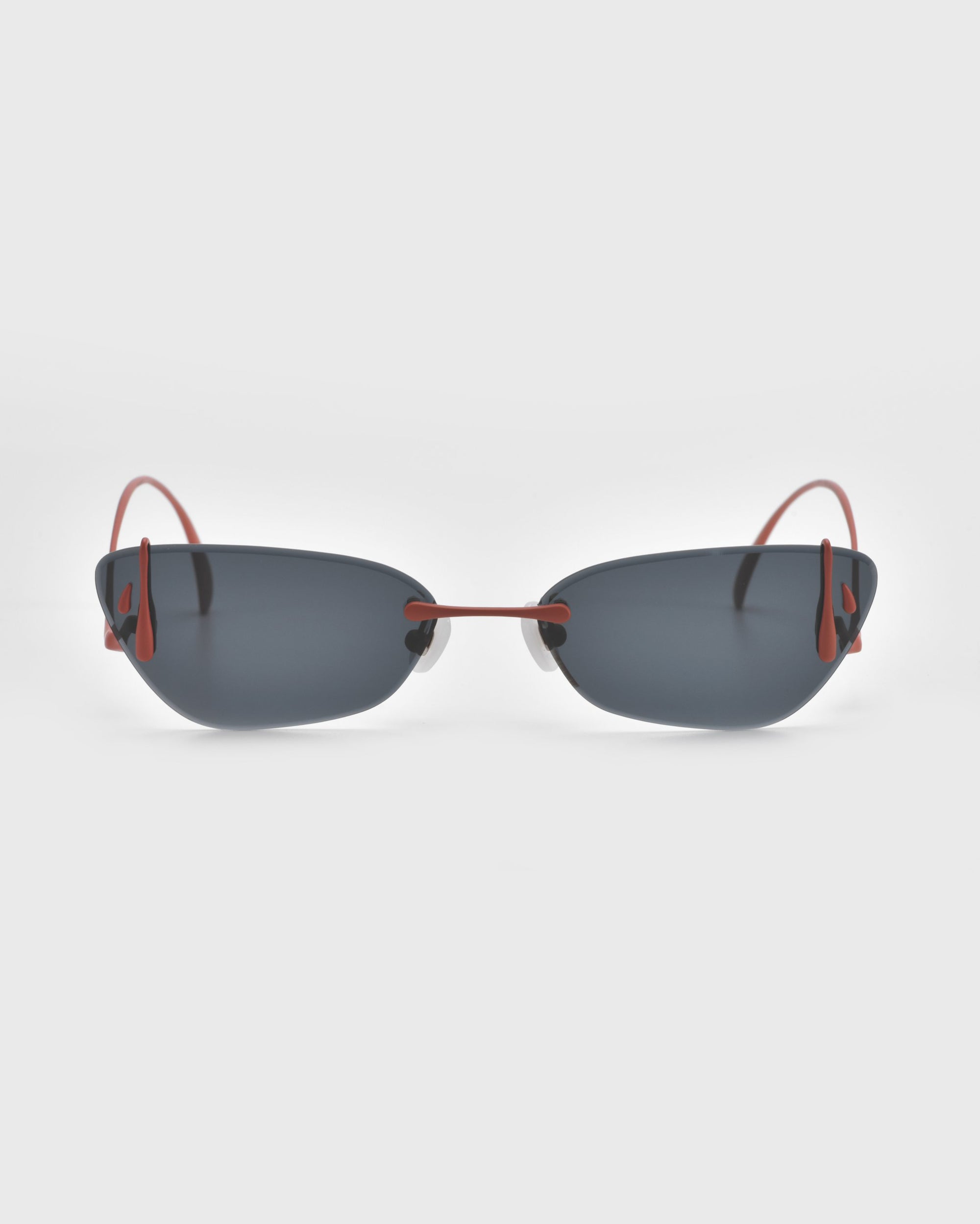 Part of For Art's Sake® Rose Garden Collection, the Crimson sunglasses showcase an elegant frameless design with dark lenses and bold red wireframes, set against a pristine white background.