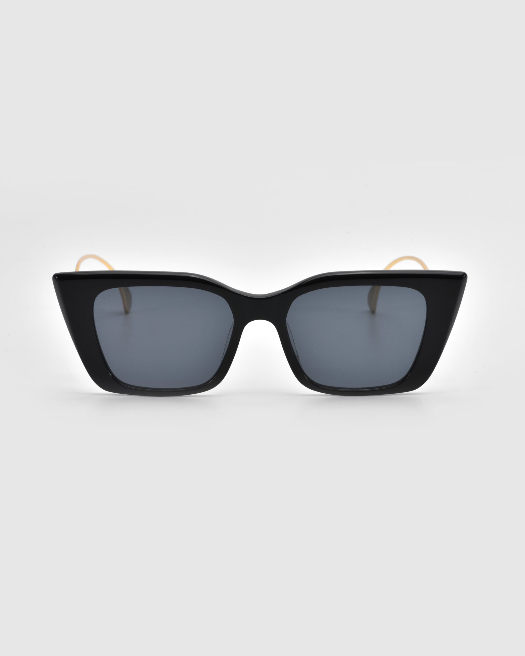 Dusk sunglasses by For Art's Sake® feature black square frames, dark lenses, and signature temples gracefully placed on a light gray background.