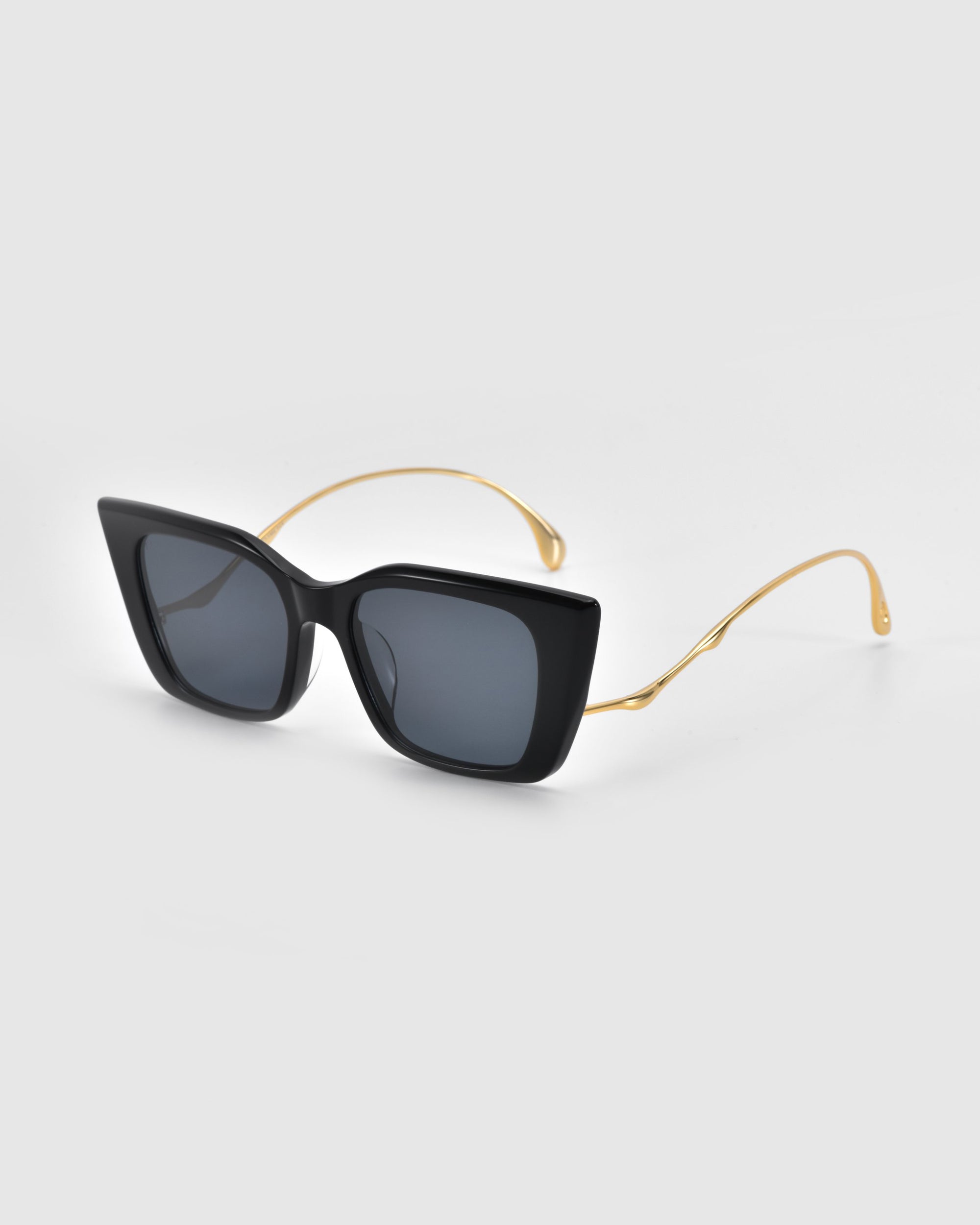 The Dusk sunglasses by For Art's Sake® feature large square black acetate frames and signature gold thin temple arms, displayed on a light grey background.