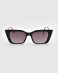 The Dusk sunglasses by For Art's Sake® feature a black cat-eye silhouette with gradient lenses, signature red temple arms, and an elegant acetate frame, displayed on a white background.