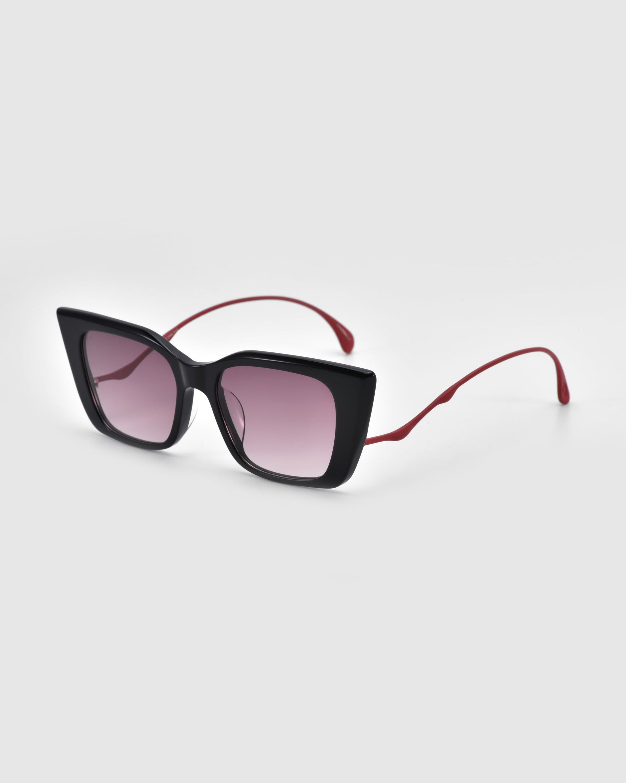 The For Art's Sake® Dusk sunglasses feature oversized black square frames with a chic cat-eye silhouette, thin red signature temples contrasting the acetate frame, and lightly tinted gradient lenses for a stylish look.