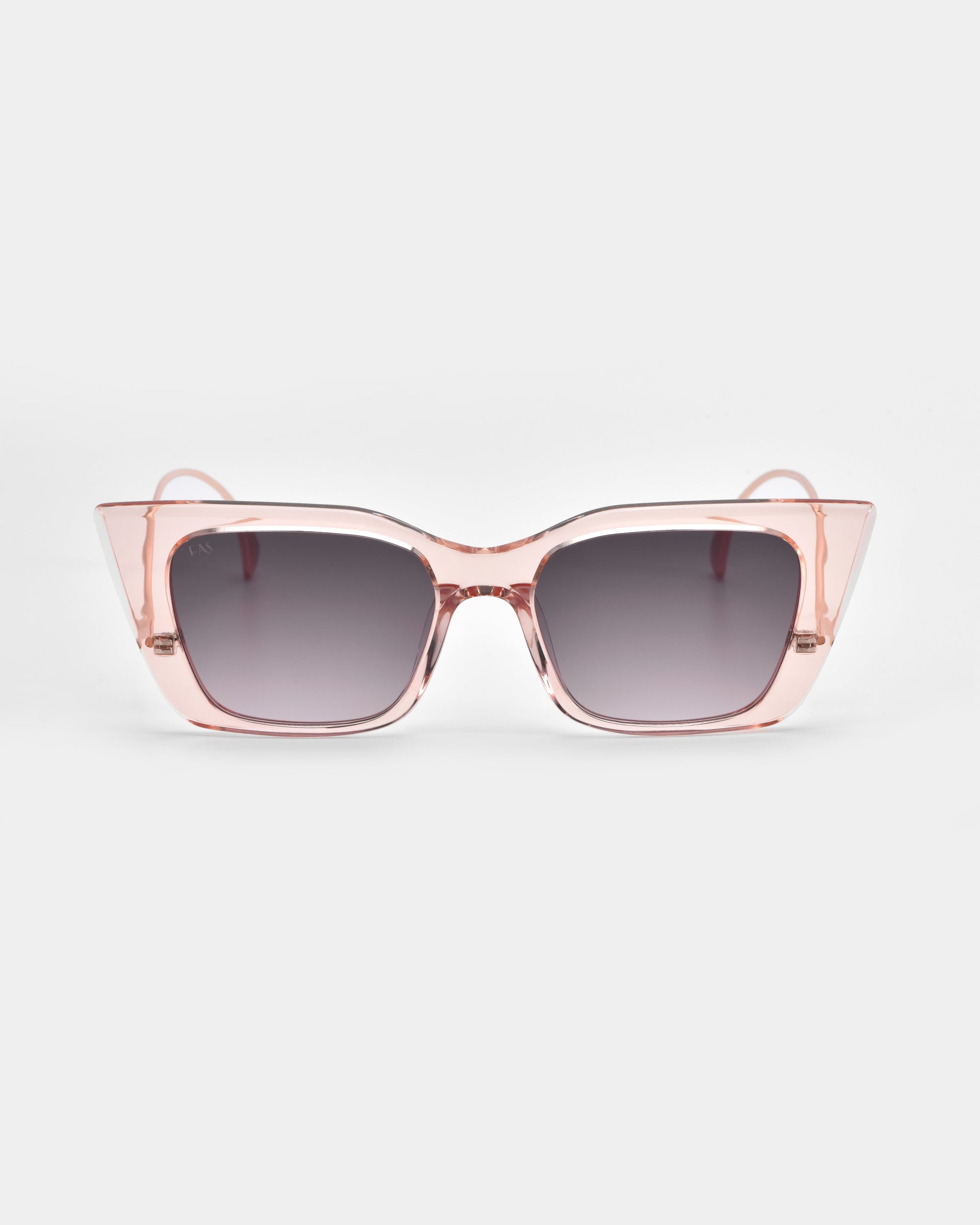 The Dusk sunglasses by For Art's Sake® feature stylish cat-eye silhouettes with transparent pink acetate frames and dark gradient lenses, showcased on a plain white background.