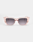 The Dusk sunglasses by For Art's Sake® feature stylish cat-eye silhouettes with transparent pink acetate frames and dark gradient lenses, showcased on a plain white background.